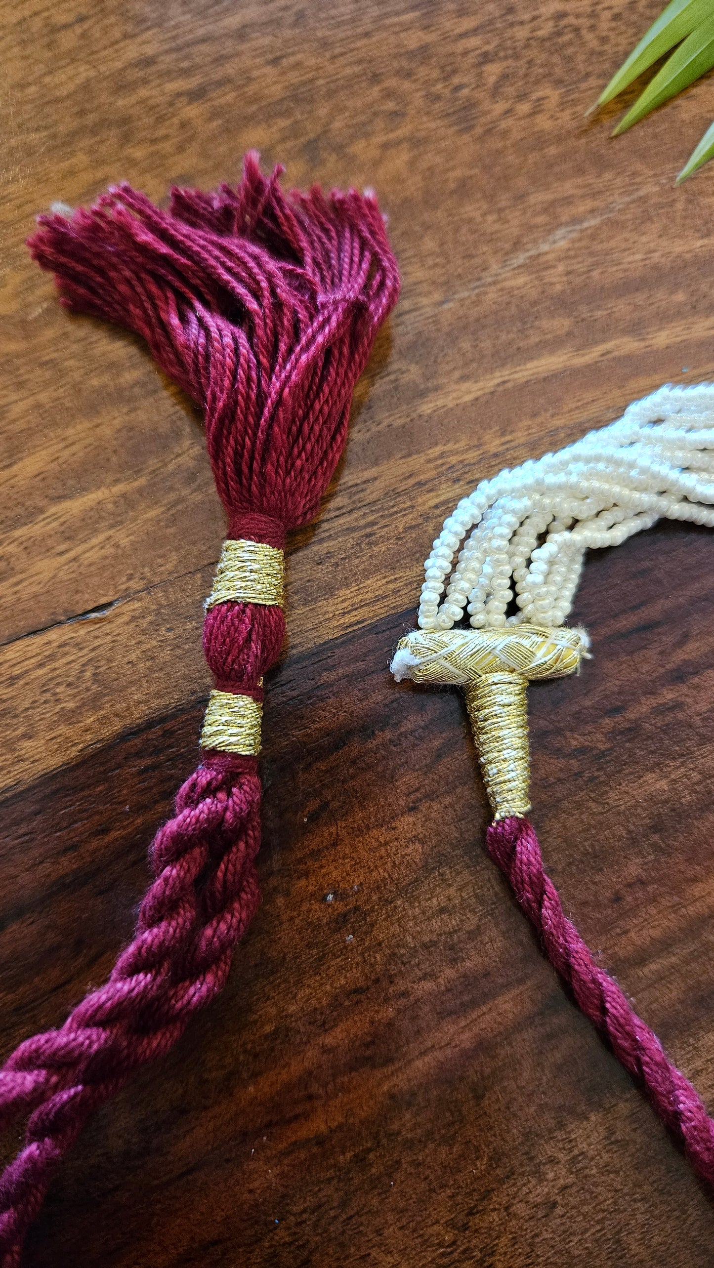 Choker (necklace) in gold finish flower shaped tikdas set with green and deep pink stone and stone hanging set on multiple pearl strands