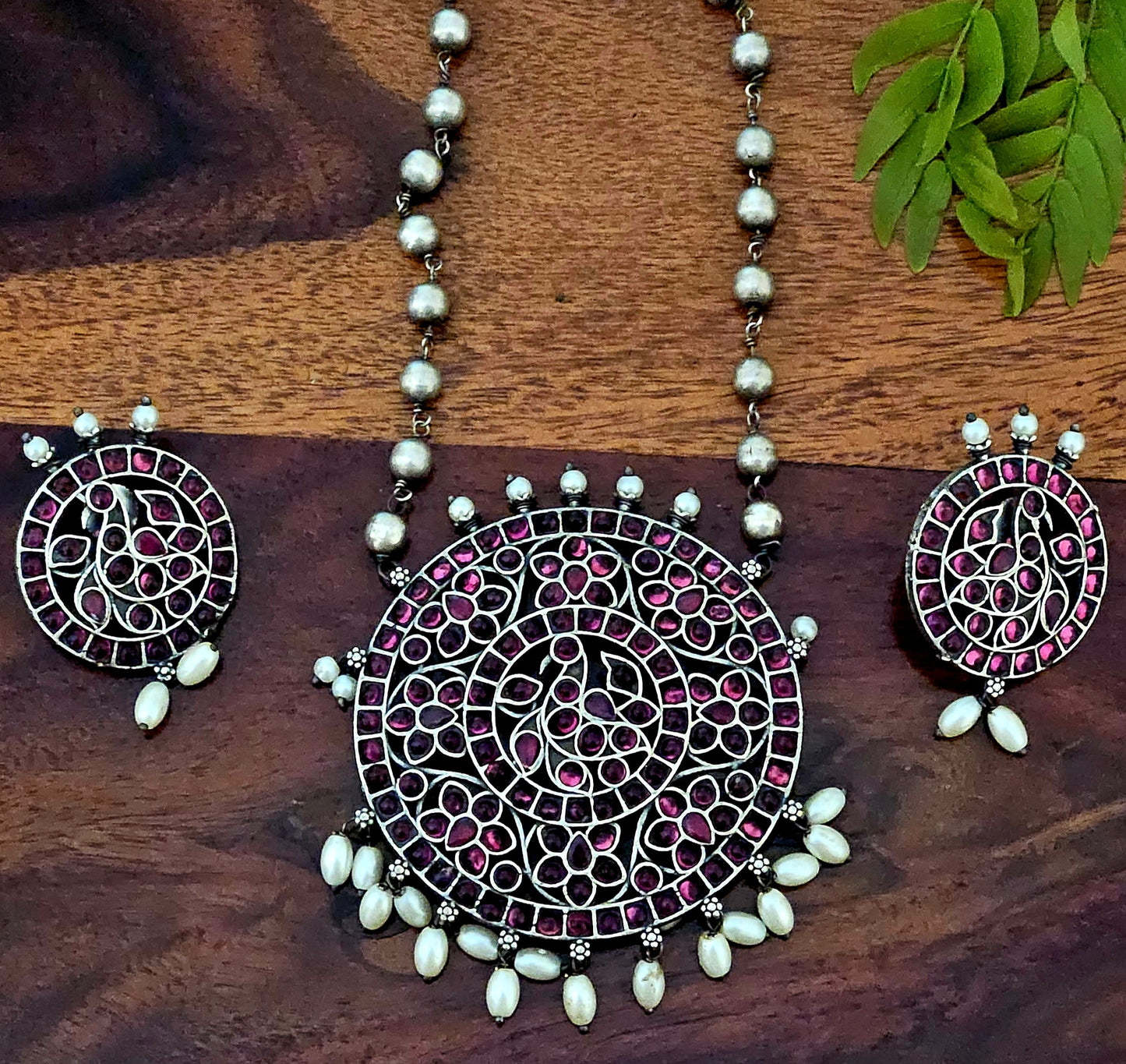 Silver finish long necklace set with big round pendant embellished with green/red stones, matching studs (earrings)