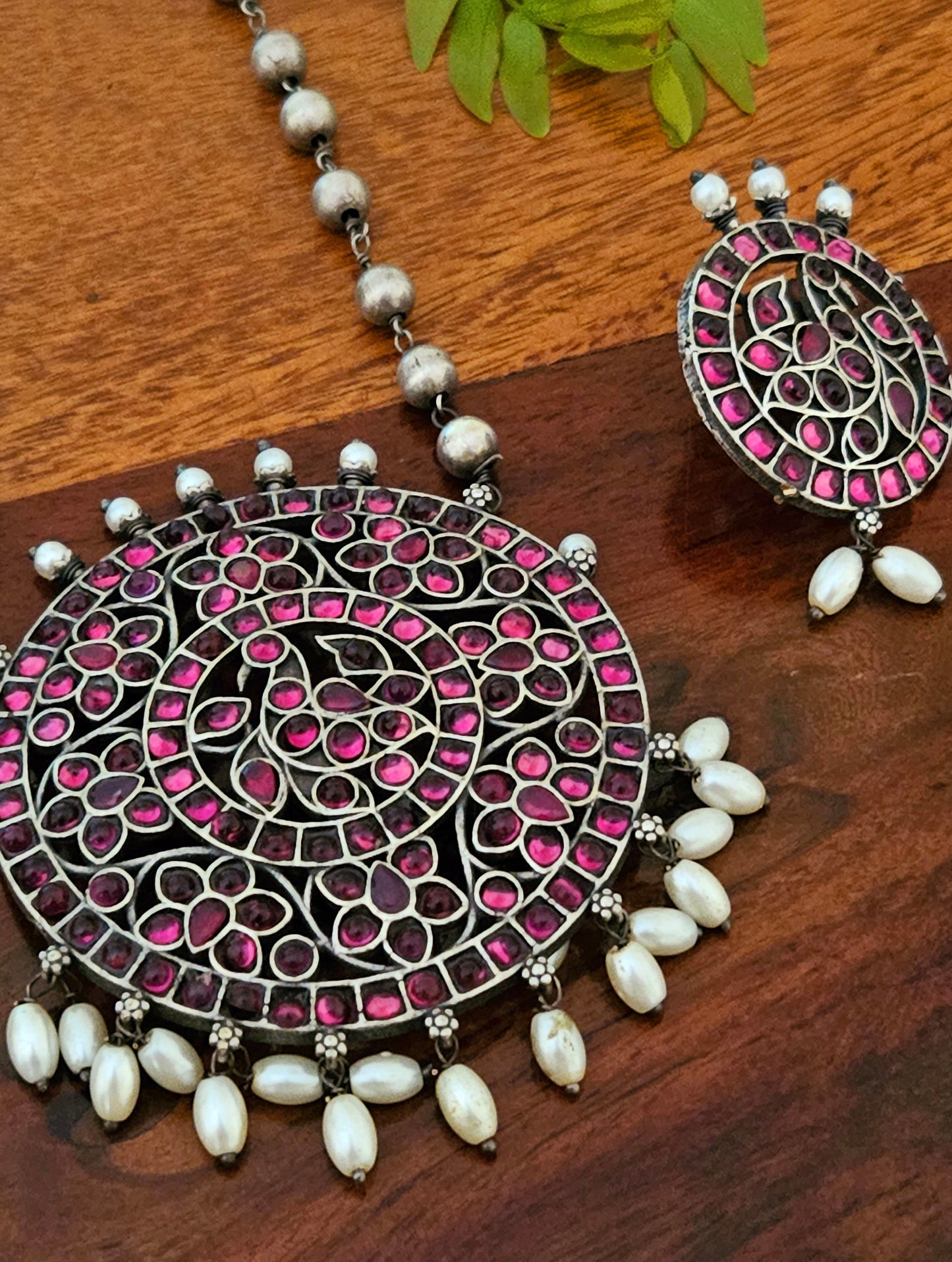 Silver finish long necklace set with big round pendant embellished with green/red stones, matching studs (earrings)