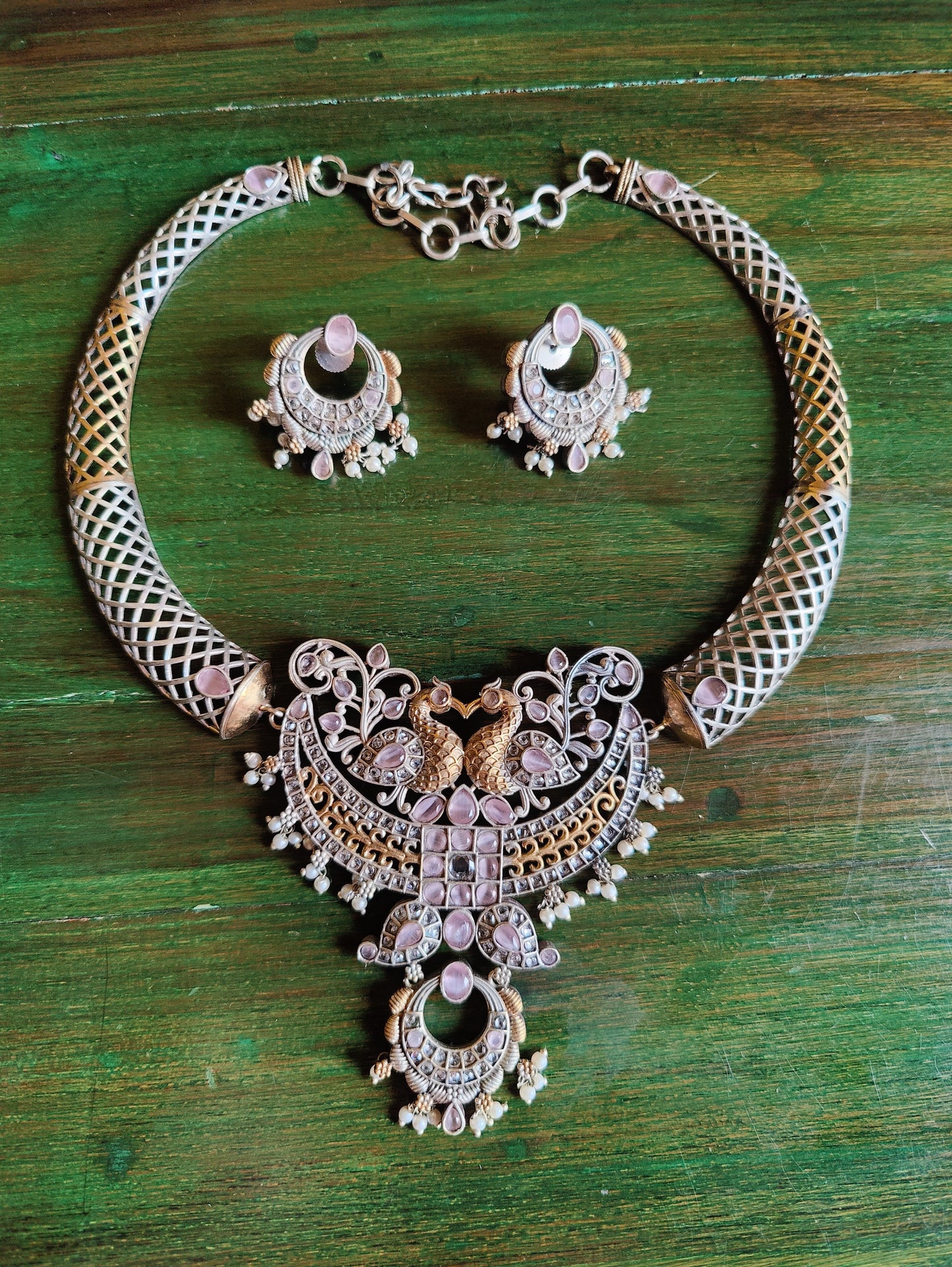 Dual tone finish set with hasli style necklace, peacock motif and mint green/pale pink stone inlay, matching earrings
