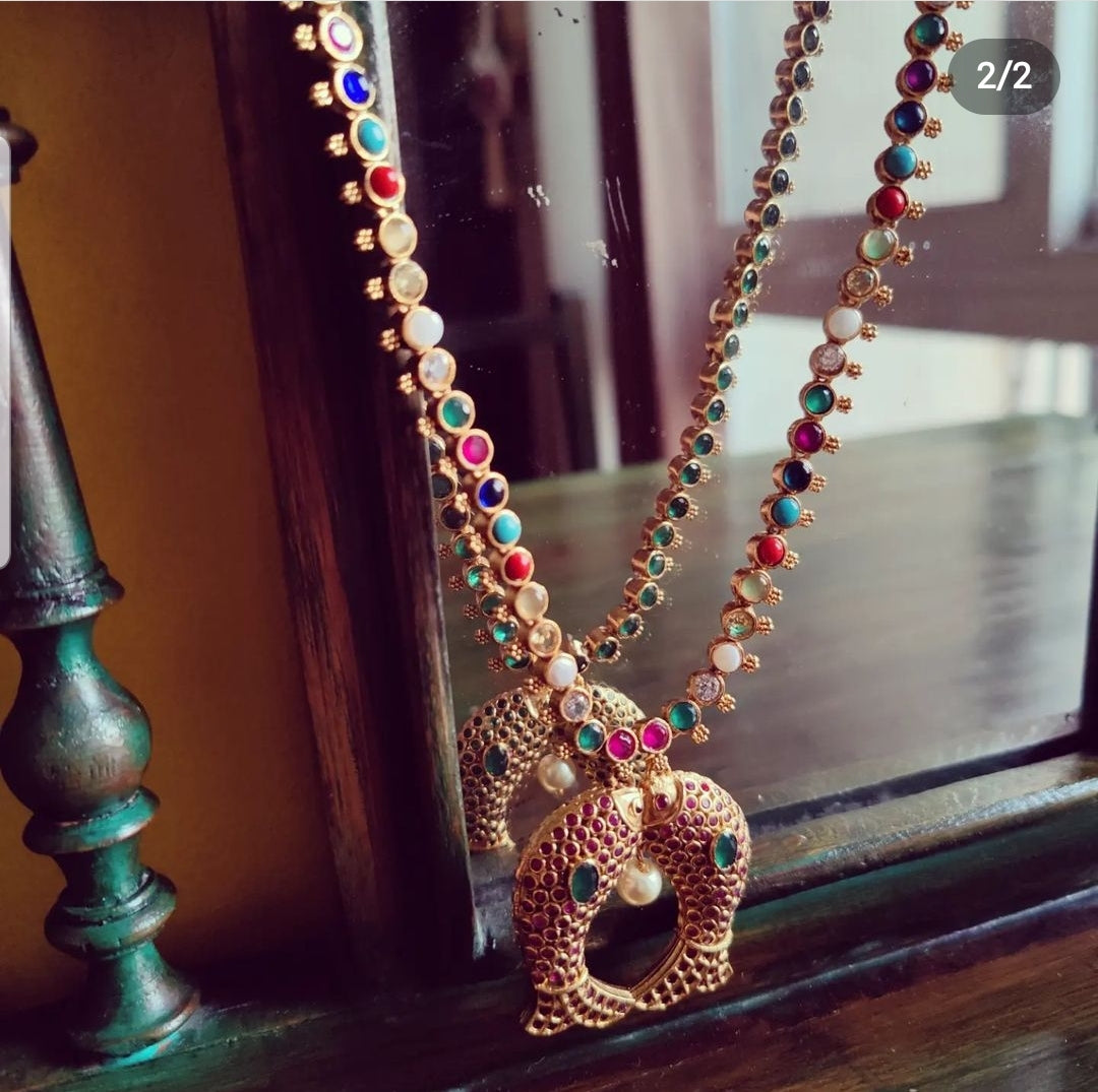 Gold finish fish motif reversible set with navratan stones on one side and emerald green/blue sapphire/ Ruby red stone inlay, matching earrings