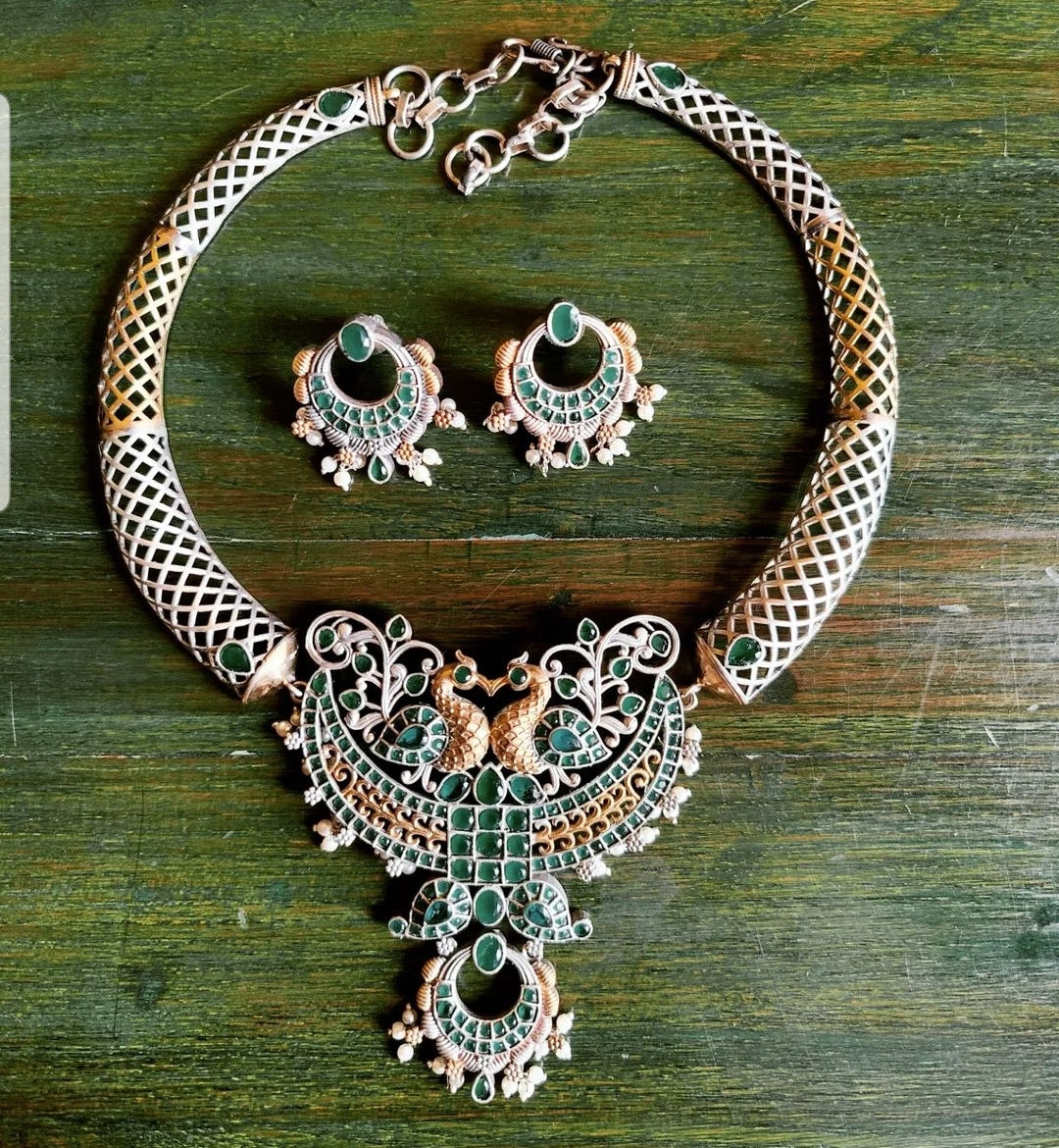 Dual tone finish set with hasli style necklace, peacock motif and mint green/pale pink stone inlay, matching earrings