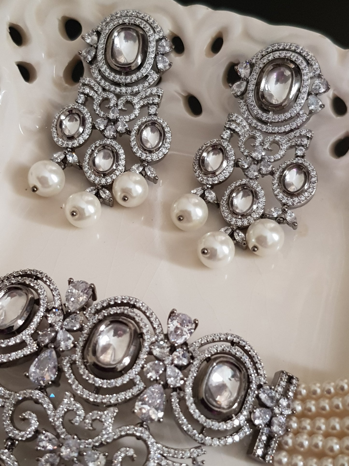 Platinum finish choker set,kundan and CZ detailing with big pearl drops , matching earrings