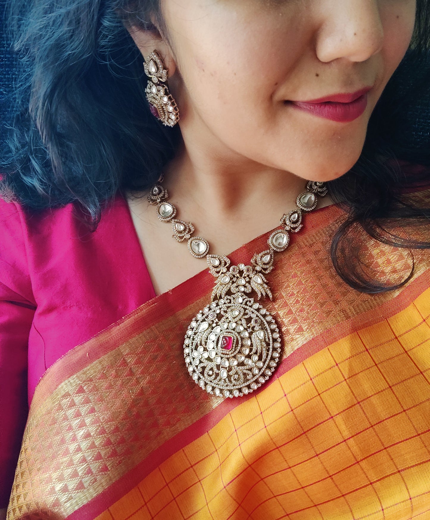 Kundan necklace and earrings set with a statement centerpiece flanked by stone studded peacocks