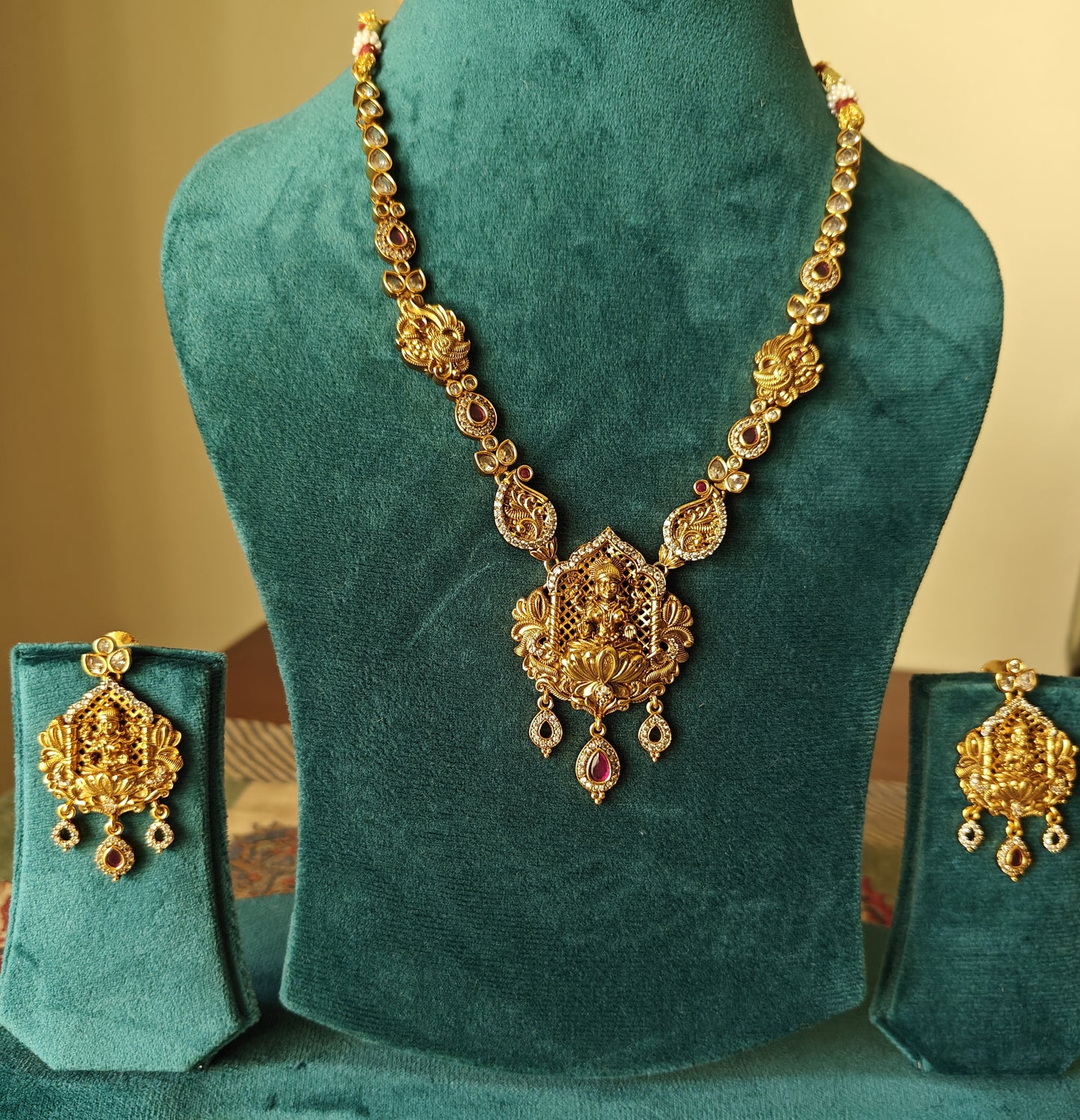 A delicate Temple Jewelry set with Lakshmi pendant with ruby red/CZ stone highlights