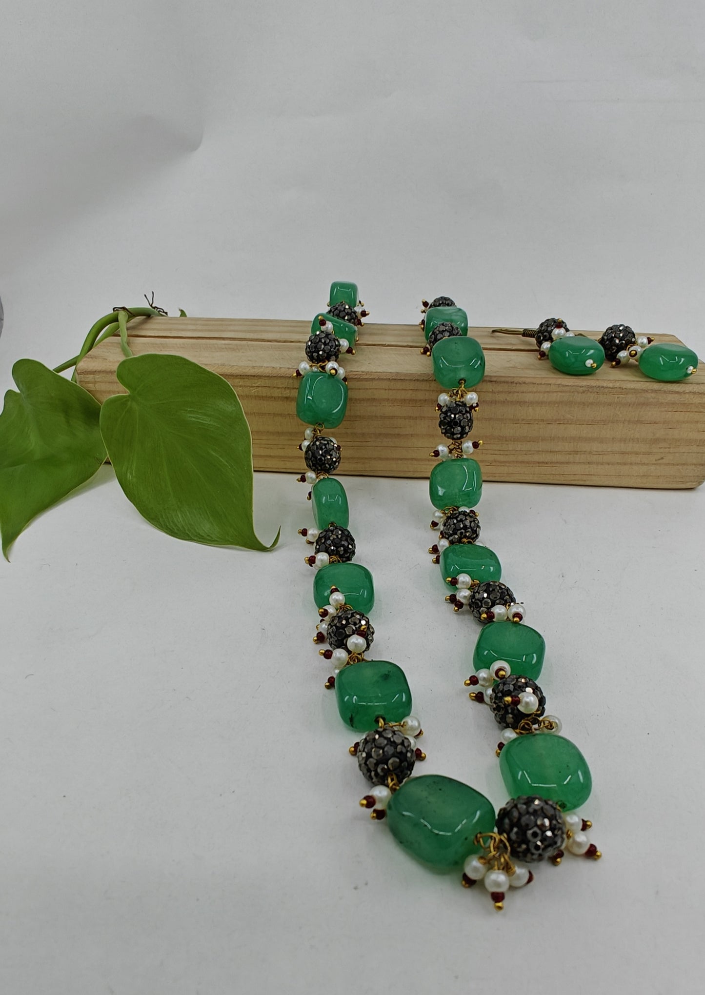 Set in green and metal beads with pearl accents