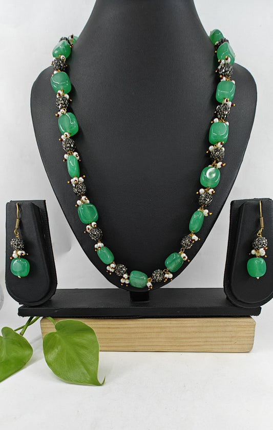 Set in green and metal beads with pearl accents