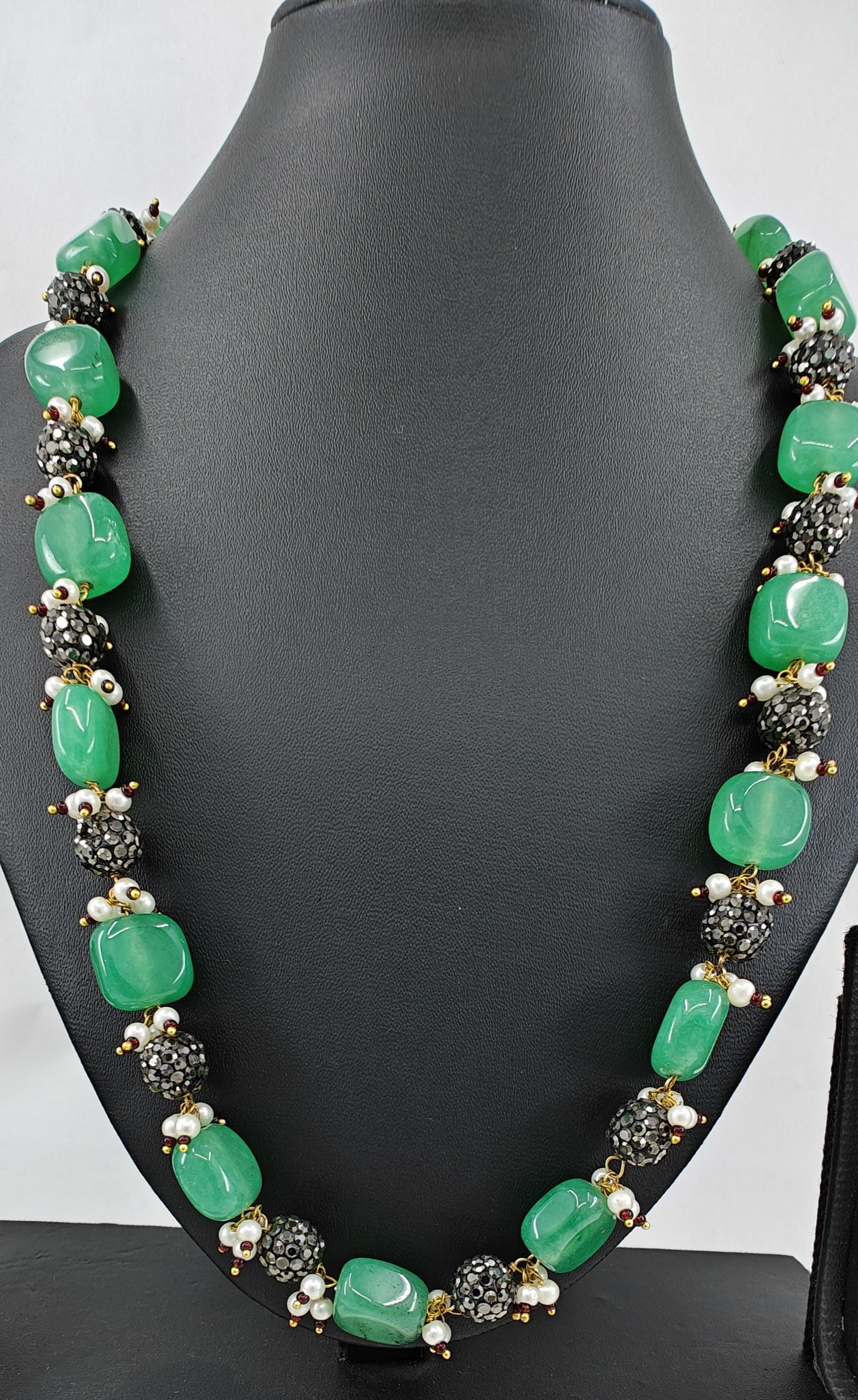 Set in green and metal beads with pearl accents