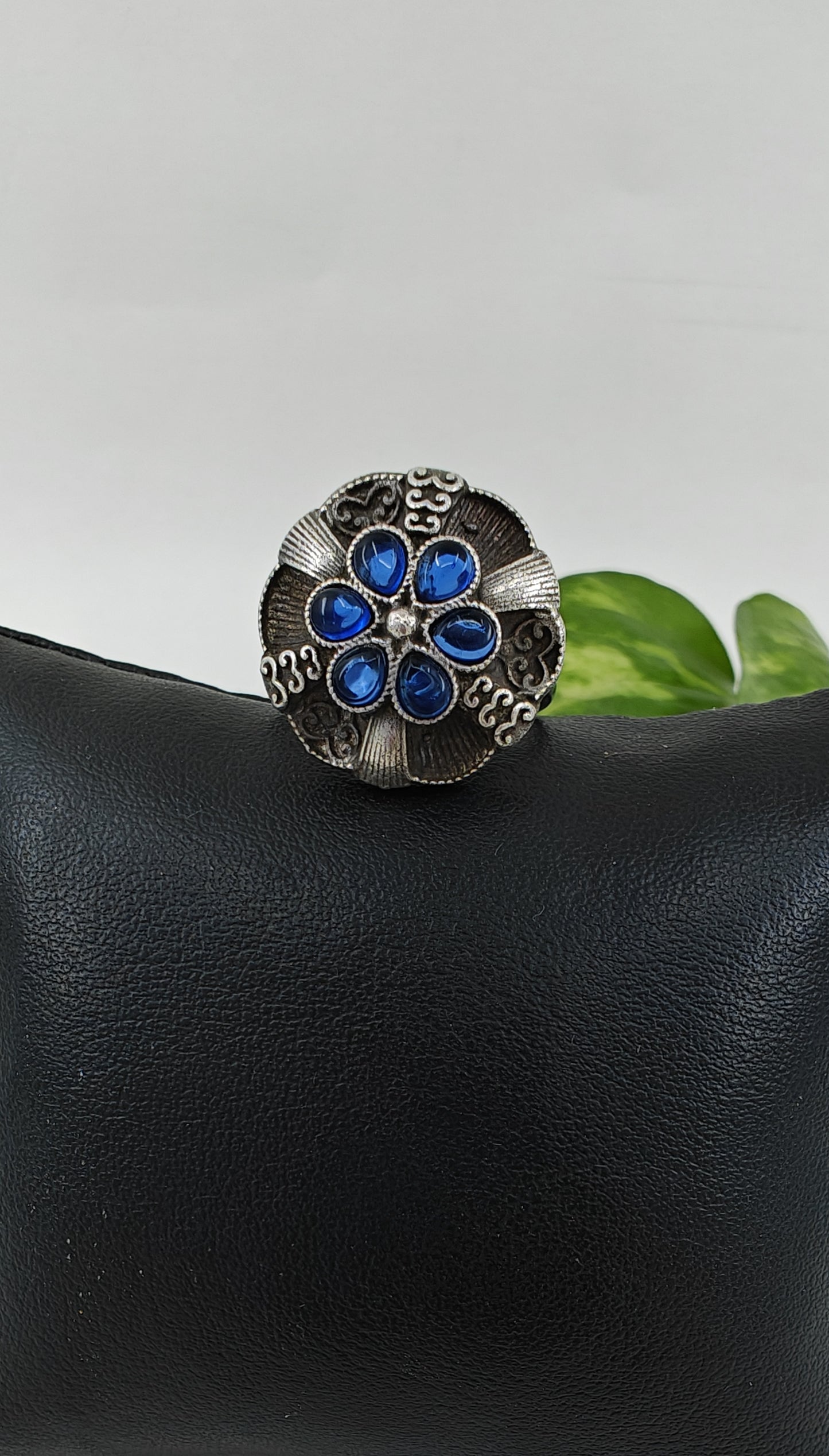 Silver ring with a raised flower with stones