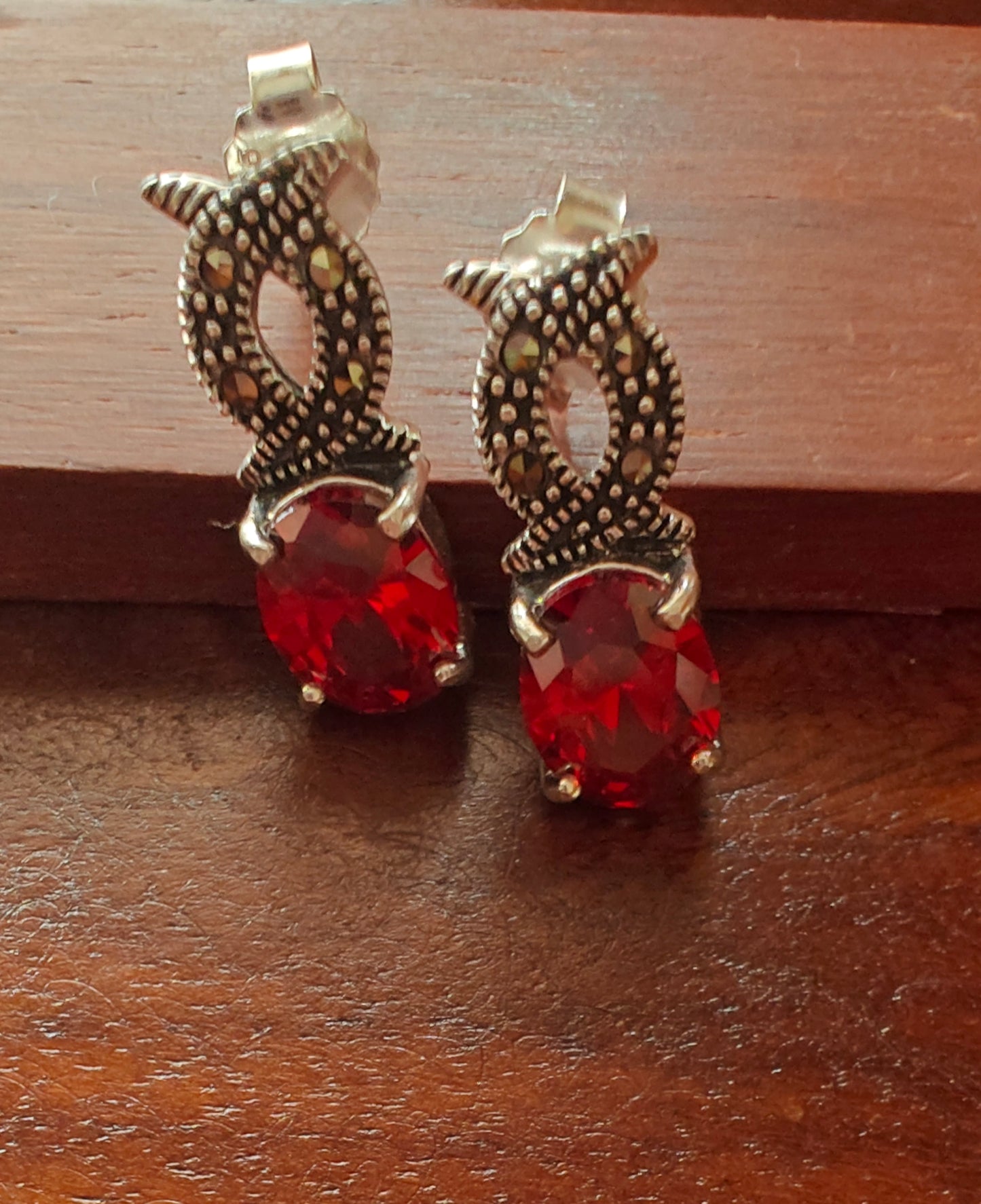 Silver infinity earrings with ruby red stone