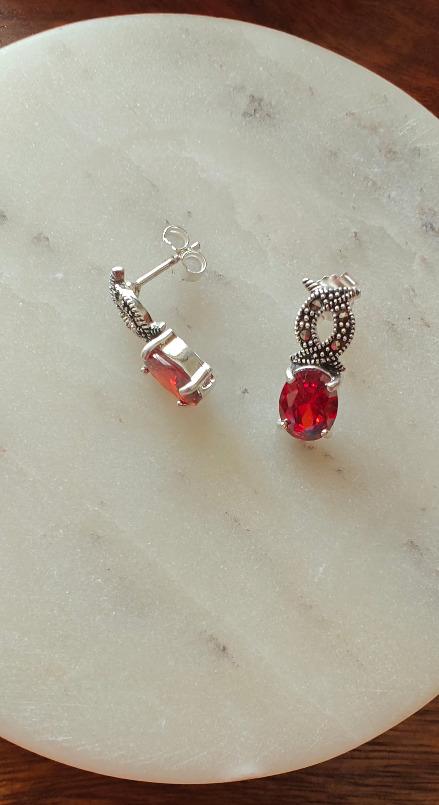 Silver infinity earrings with ruby red stone