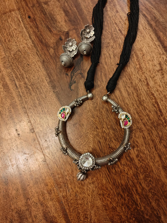 Dual tone tribal necklace set with a round centre piece with work on black thread