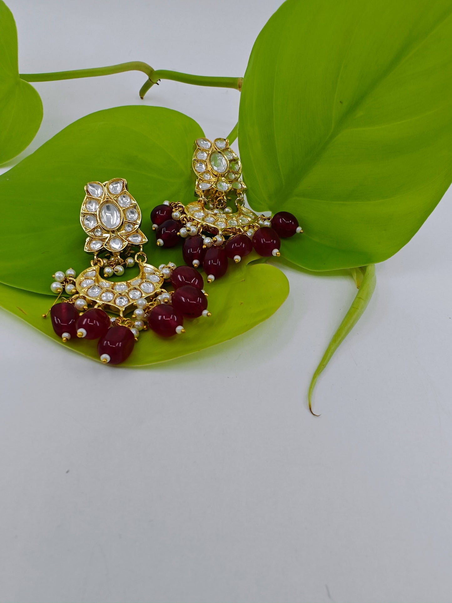 Earrings in gold finish with Kundan and red stone hangings