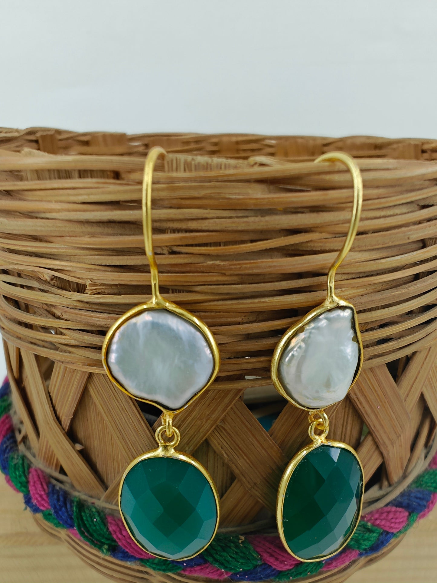 Golden danglers(earrings) with baraque pearl on top and green stone at the bottom