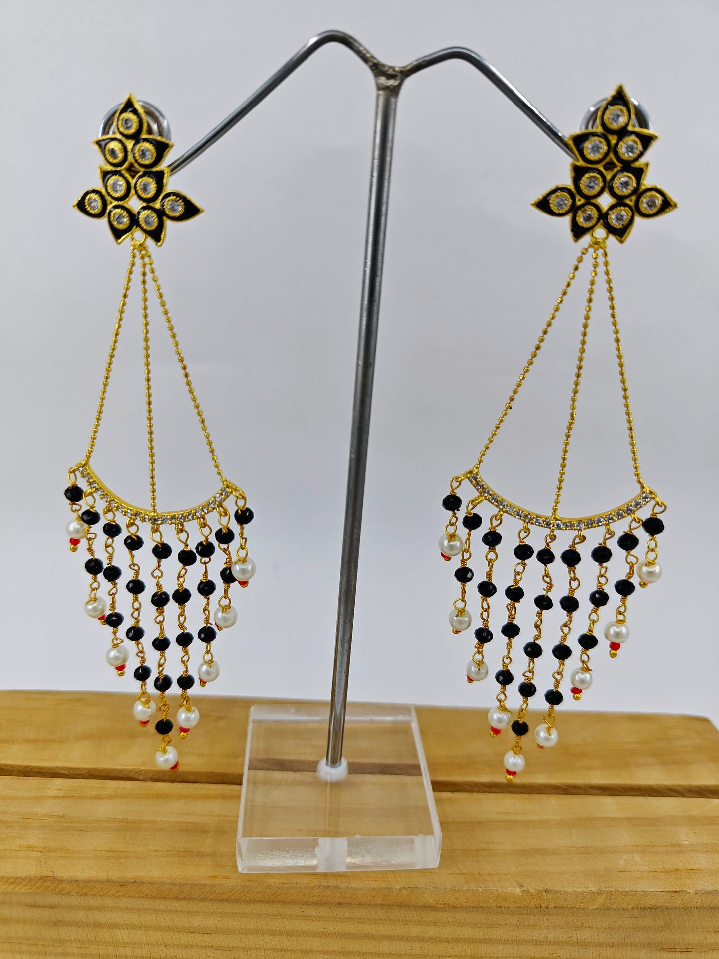 Earrings in gold finish, delicate long danglers with black meenakari and stone hangings