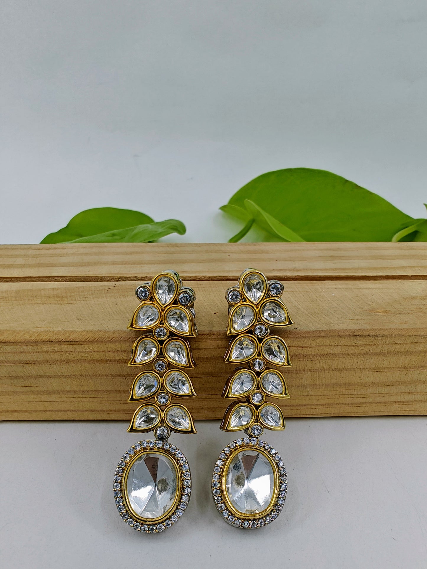 Long Kundan earrings with oval kundan hanging on kundan leaf twig