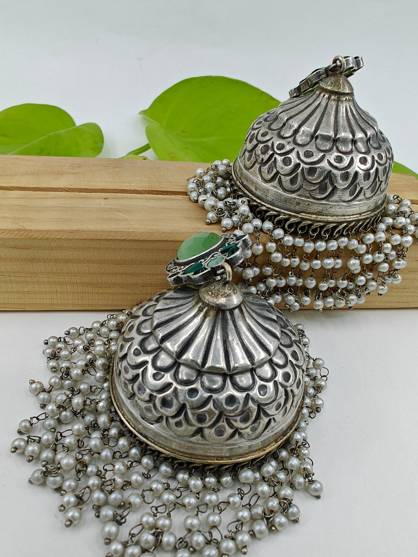 Big Jhumkas (earrings)with green stone on stud and hanging pearls at the botton