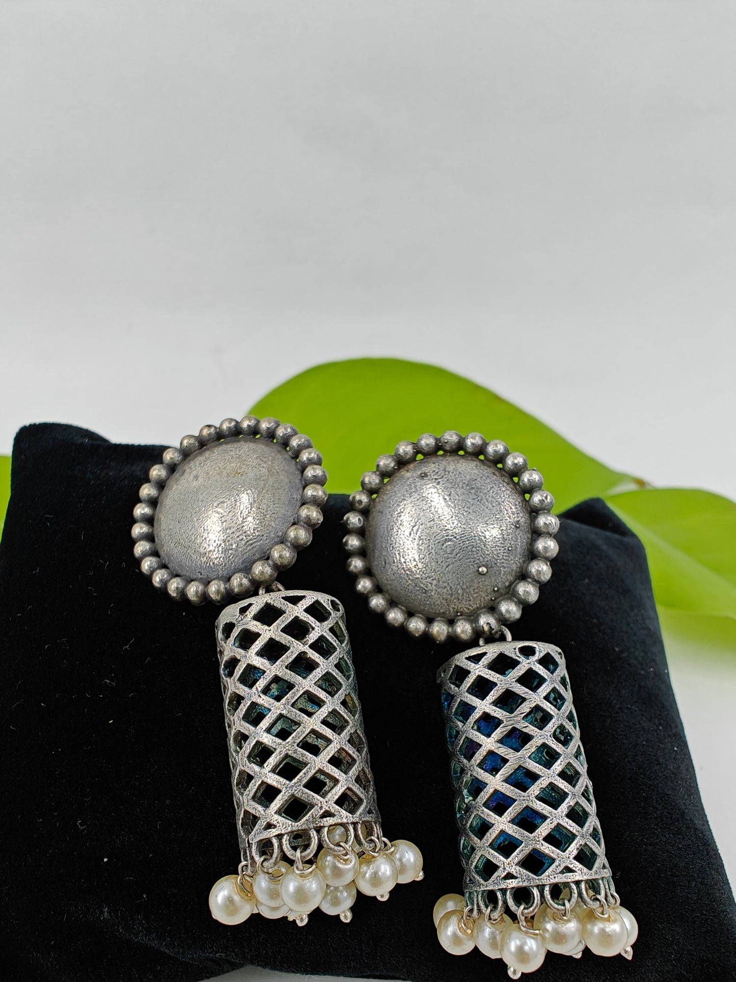 Earrings(jhumkis)in silver finish in cylindrical shape with pearl hangings