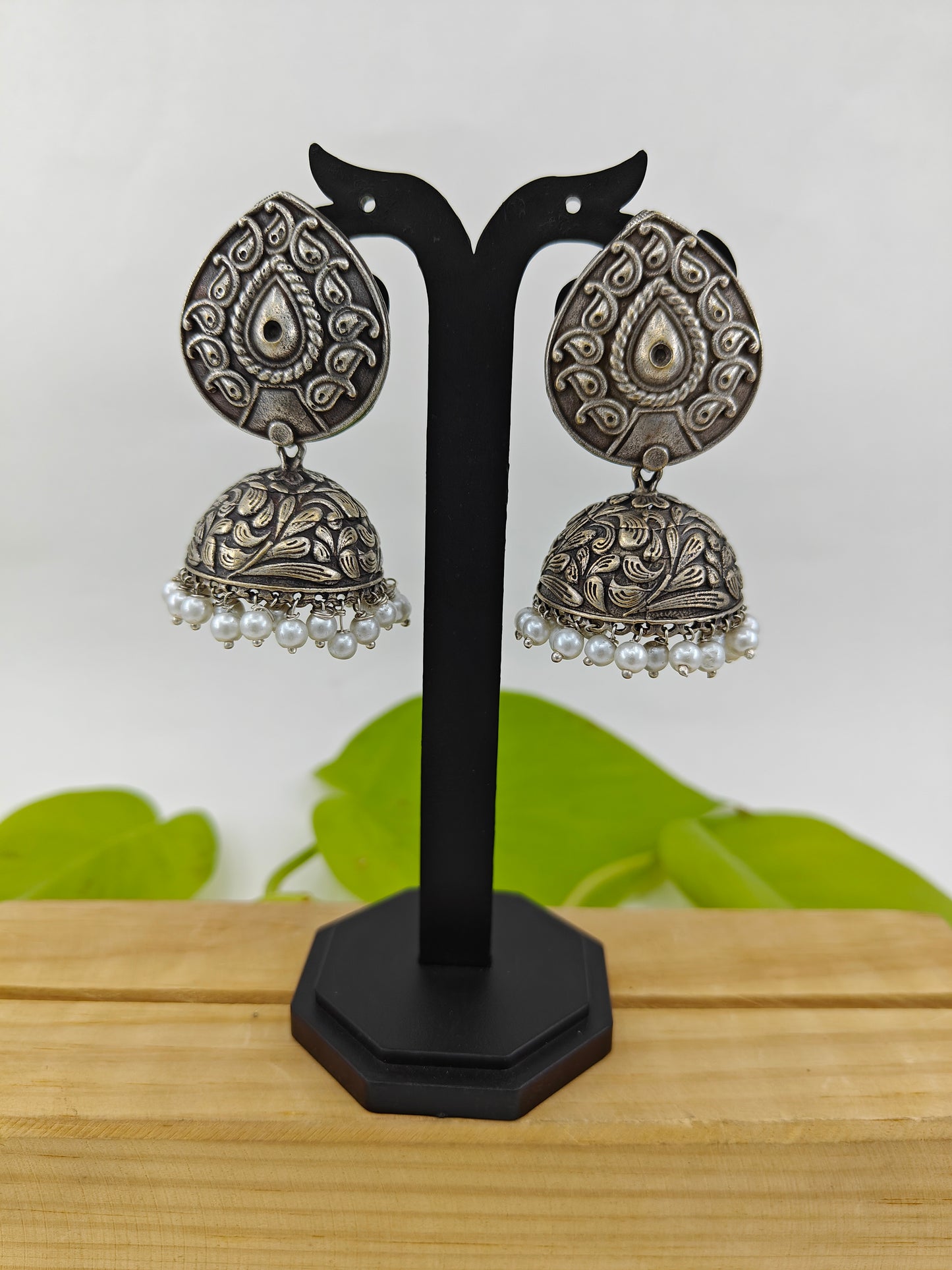 Earrings ( jhumkis) with pearl on drop shaped stud in silver finish