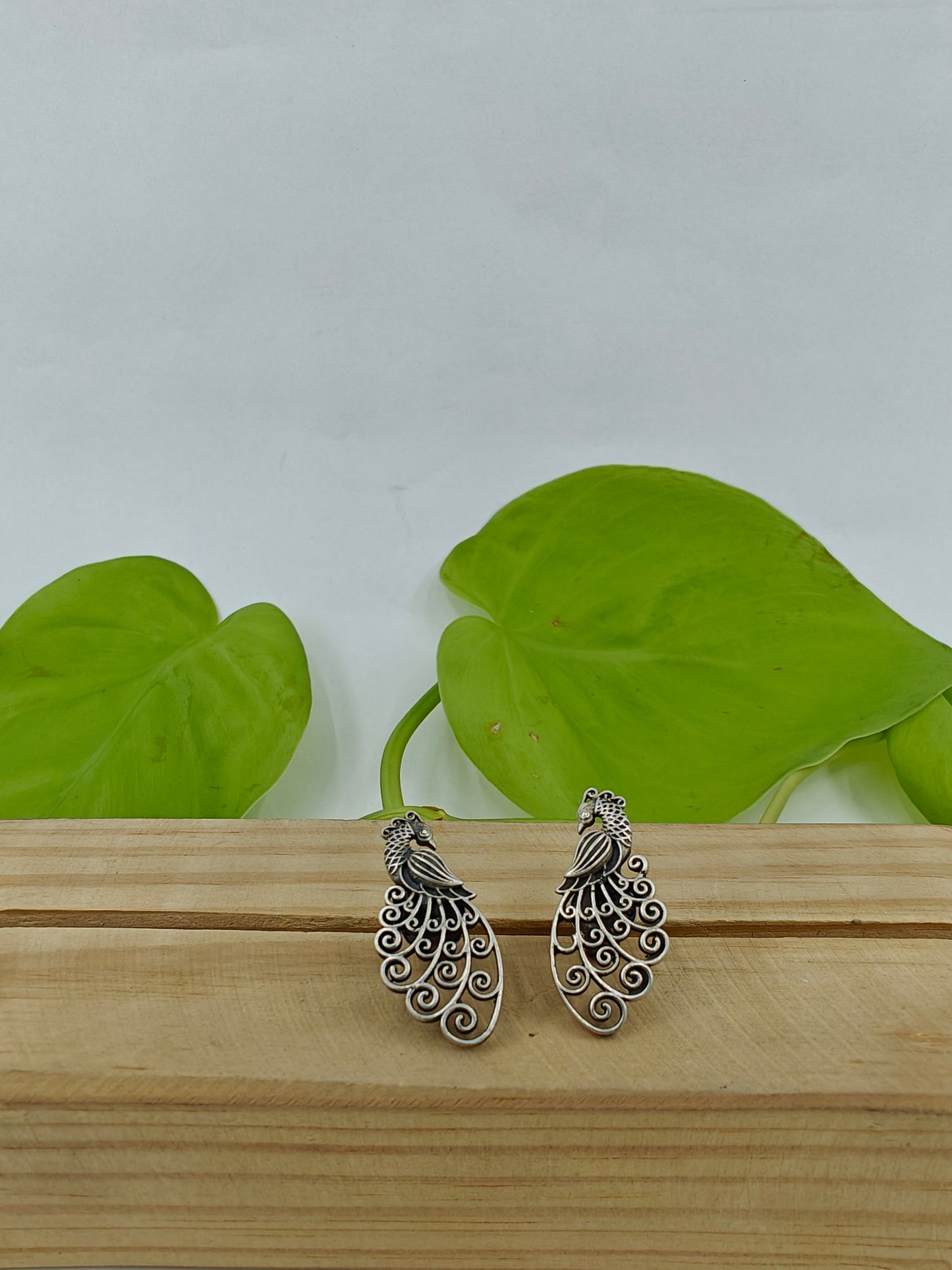 Silver peacock stud (earrings) with intricate jali work