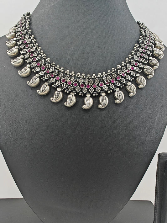 Silver necklace in chattai design with ruby inlay and paisley pieces hanging at the bottom