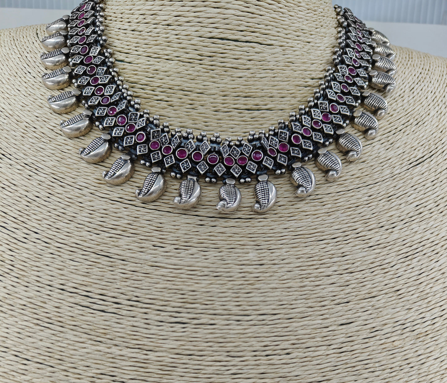 Silver necklace in chattai design with ruby inlay and paisley pieces hanging at the bottom