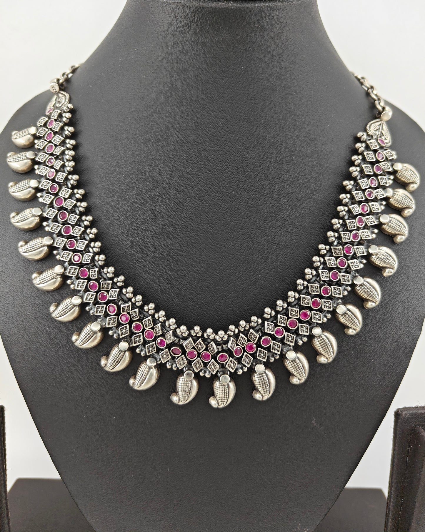 Silver necklace in chattai design with ruby inlay and paisley pieces hanging at the bottom