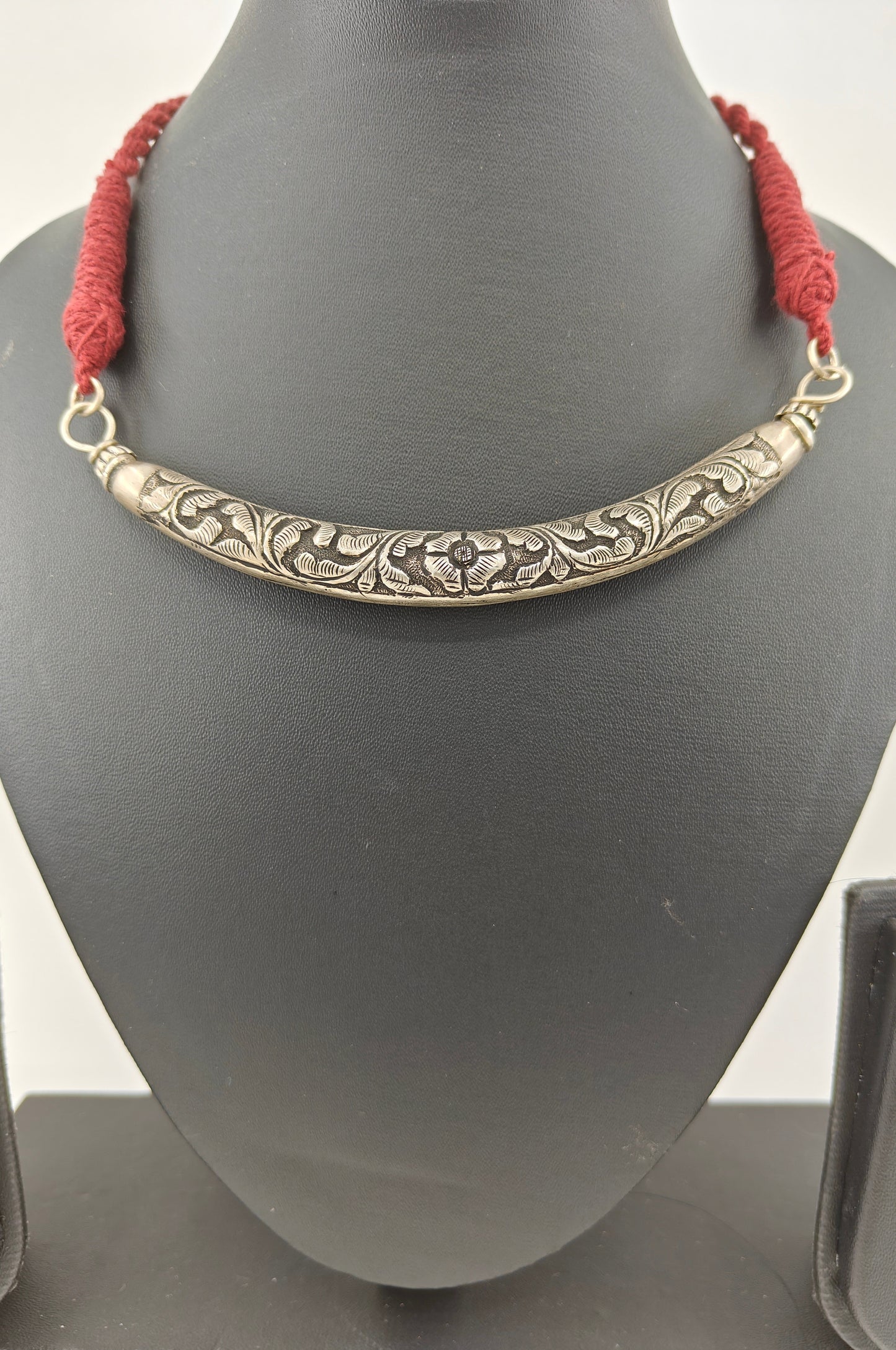 Silver choker hasli (necklace) with floral carving on a maroon thread