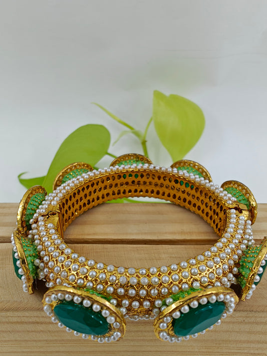 Rajwada Kara( bangle) in gold finish with jadau pearl stone all over, green stones on top