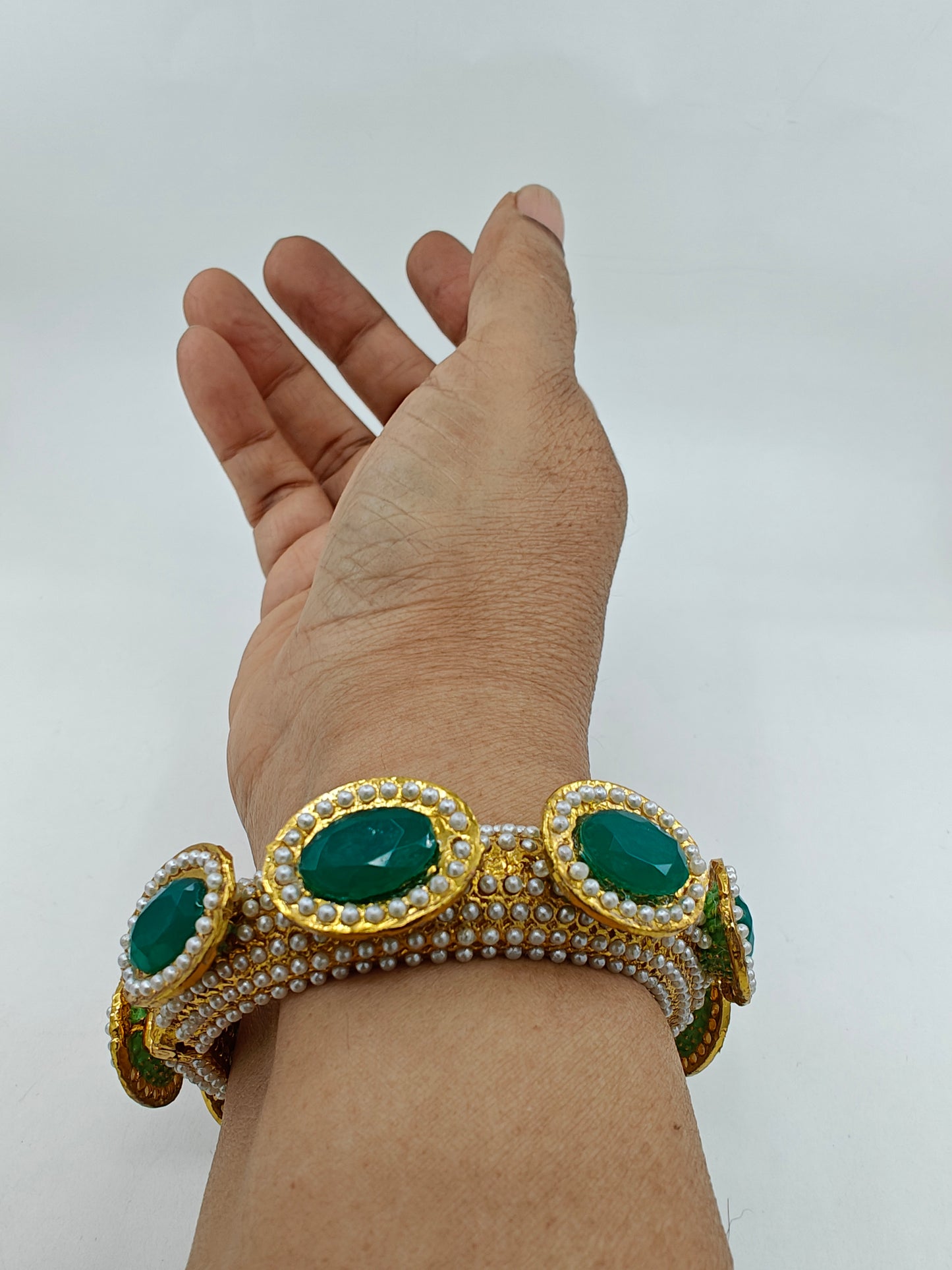 Rajwada Kara( bangle) in gold finish with jadau pearl stone all over, green stones on top