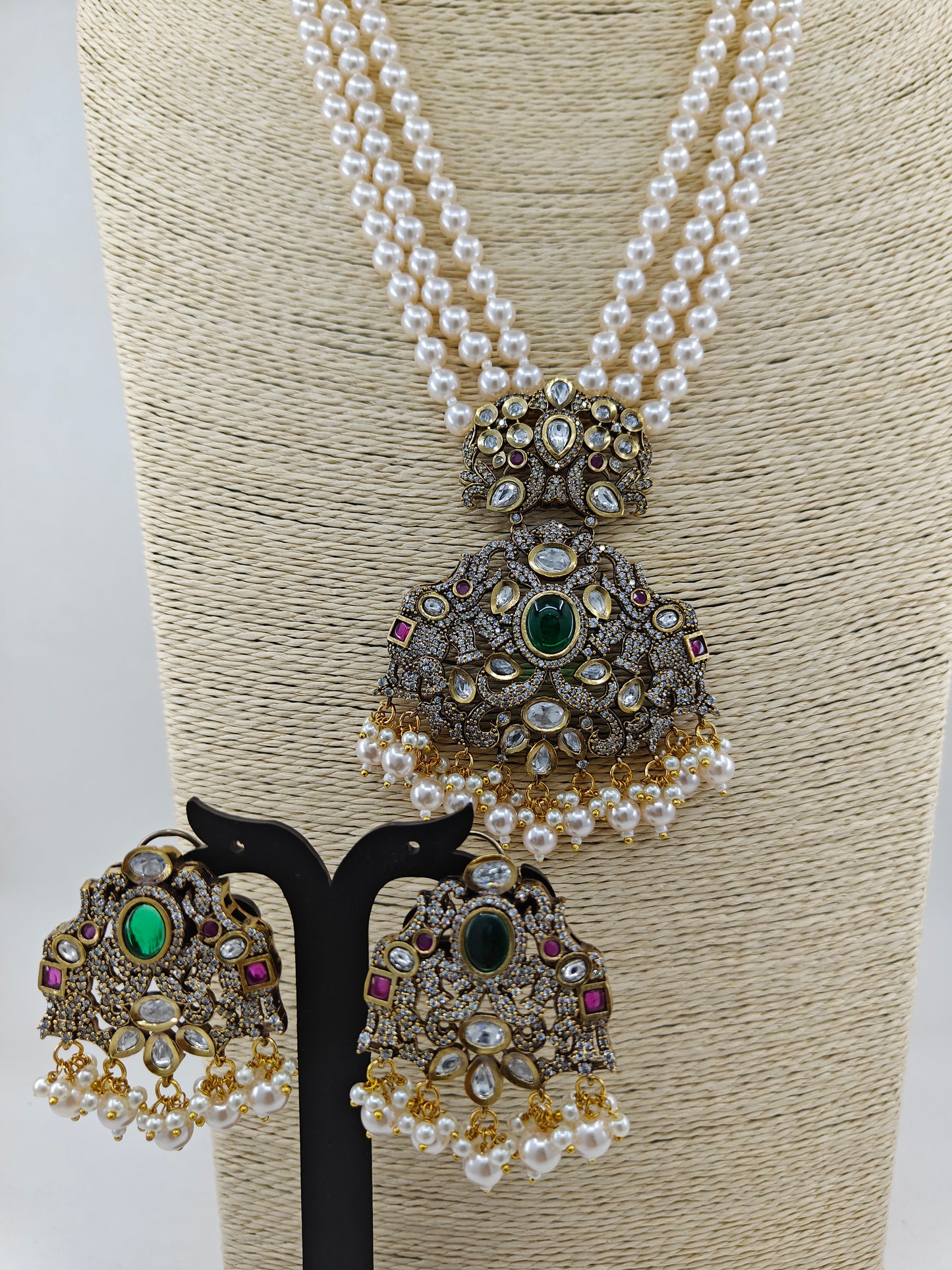 Antique finish set with a big pendant with elephant motif on a smaller piece with peacock motif set on pearl strands,matching earrings