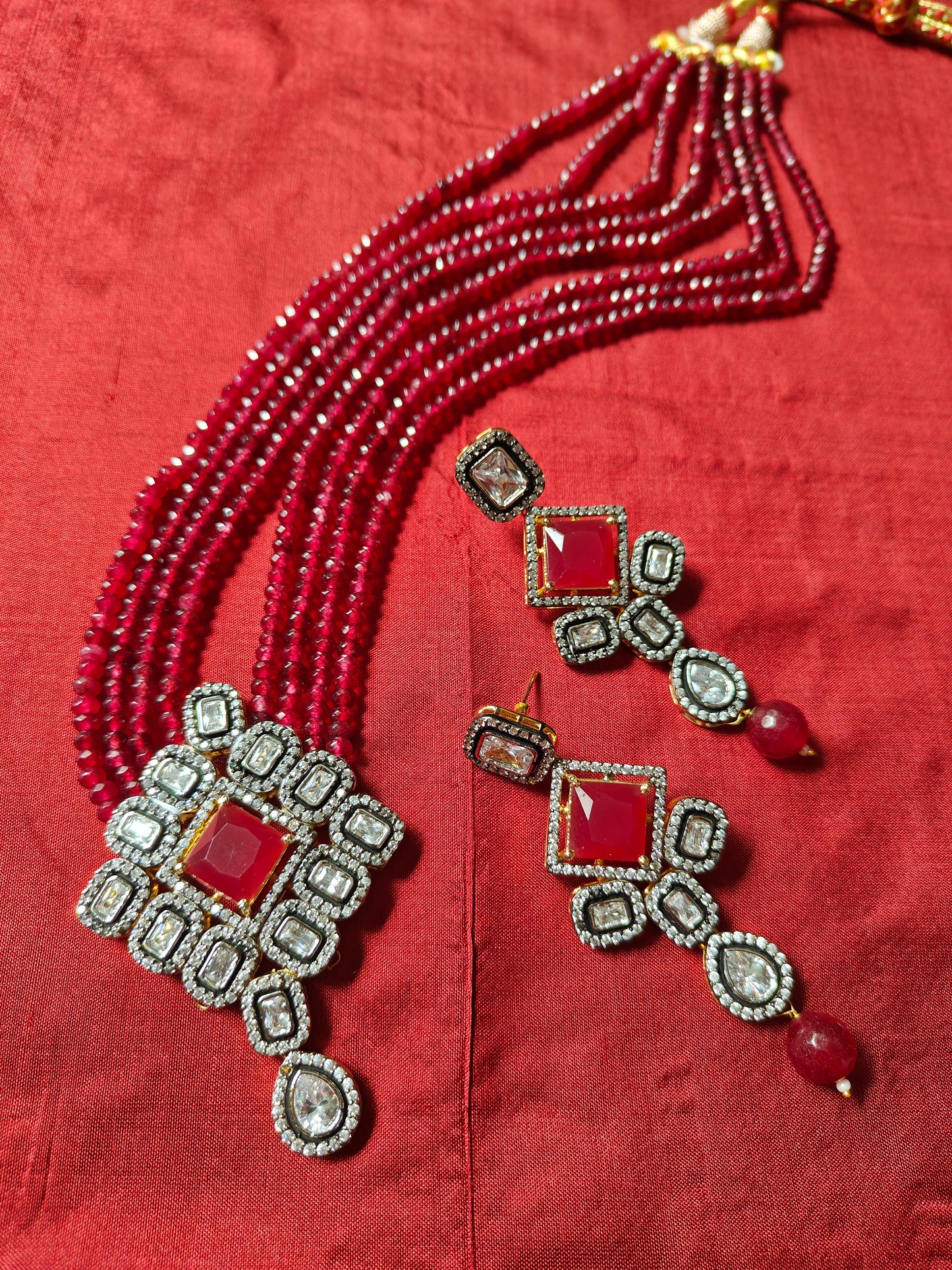 Set in antique finish,Pendant with CZ and red stone on red garnet strands,long earrings