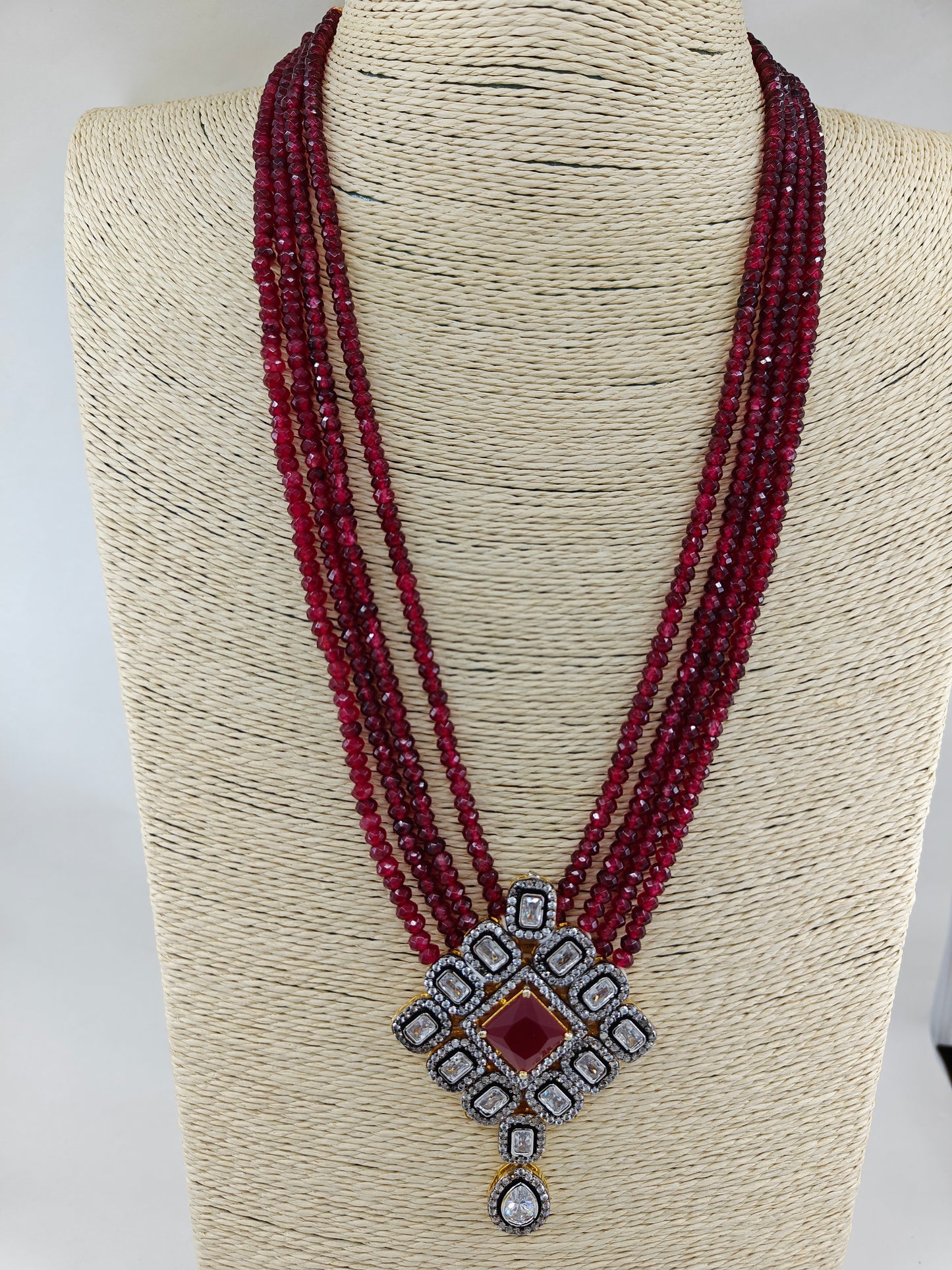 Set in antique finish,Pendant with CZ and red stone on red garnet strands,long earrings