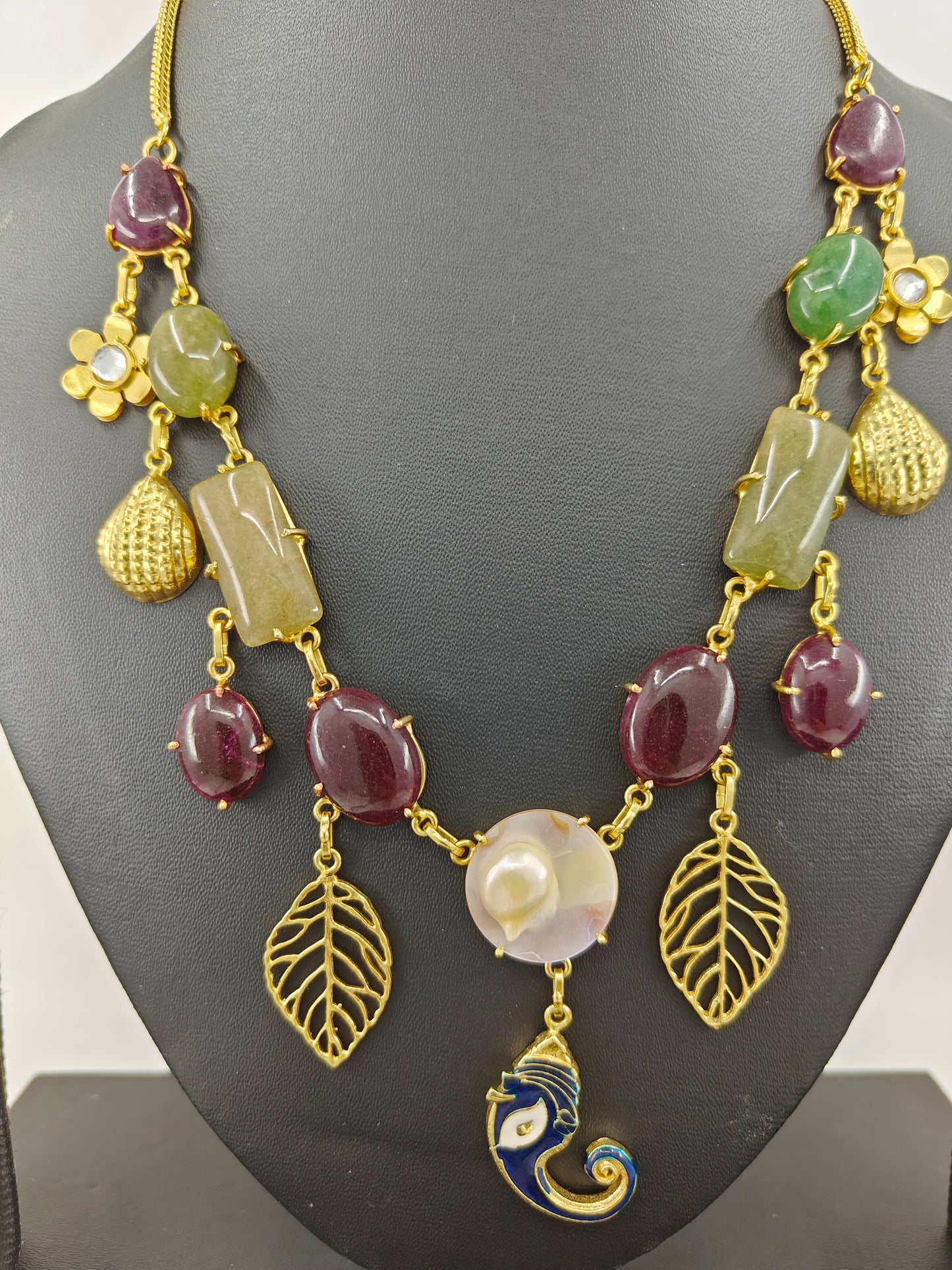 Necklace in gold finish with stones and different hangings