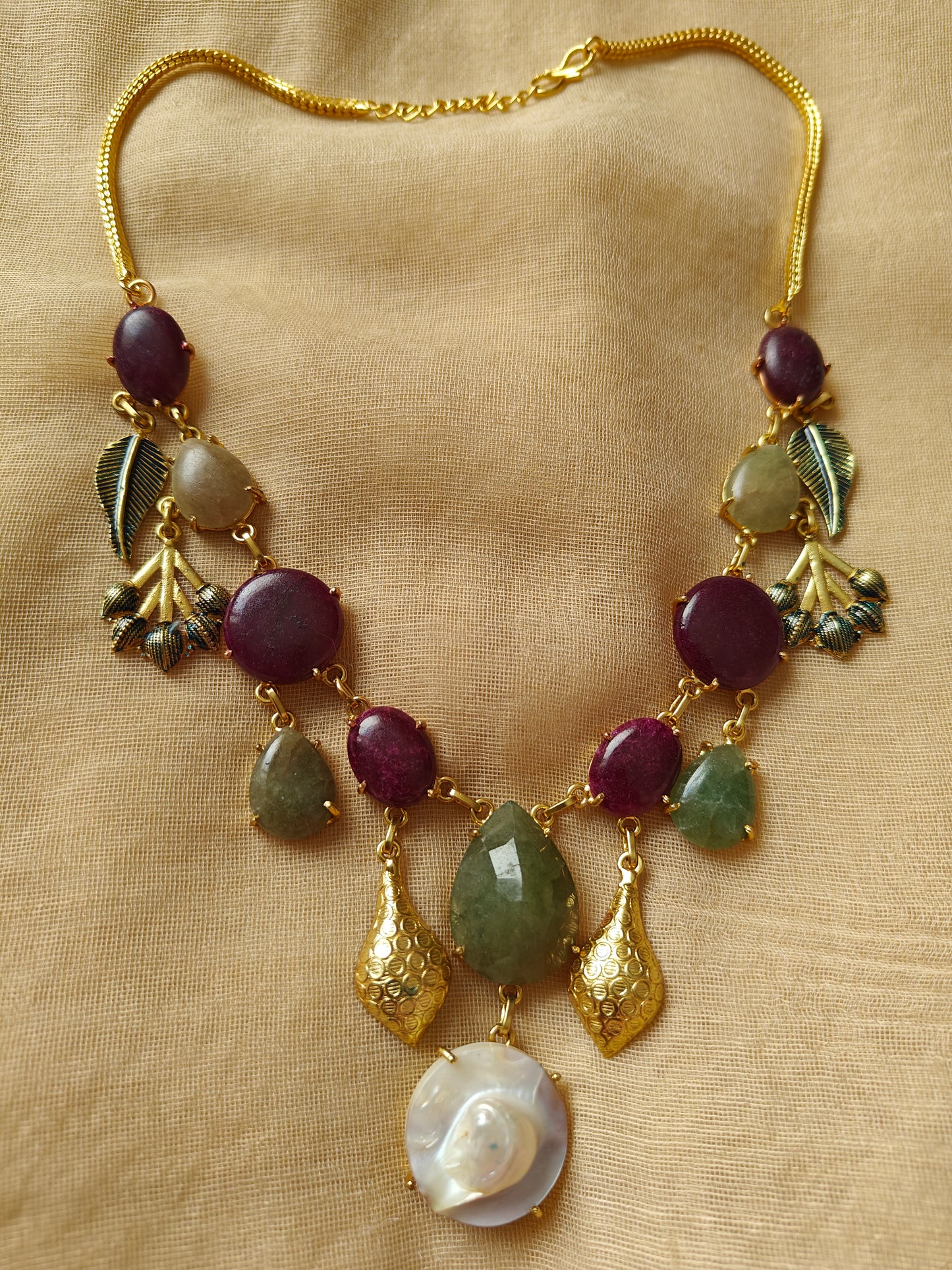 Necklace in gold finish with stones and different hangings