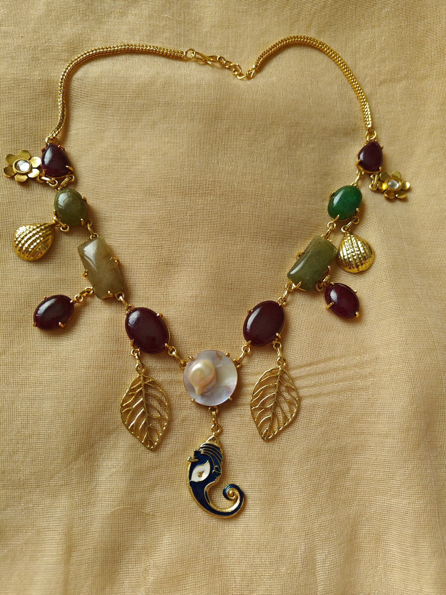 Necklace in gold finish with stones and different hangings