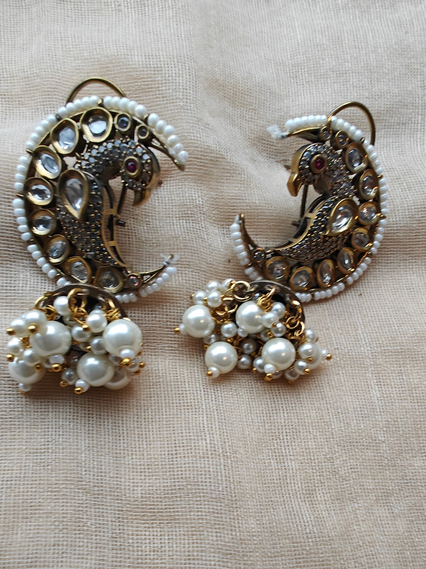 'Chaand-mor' jhumki earrings featuring a peacock nestled in a cresent