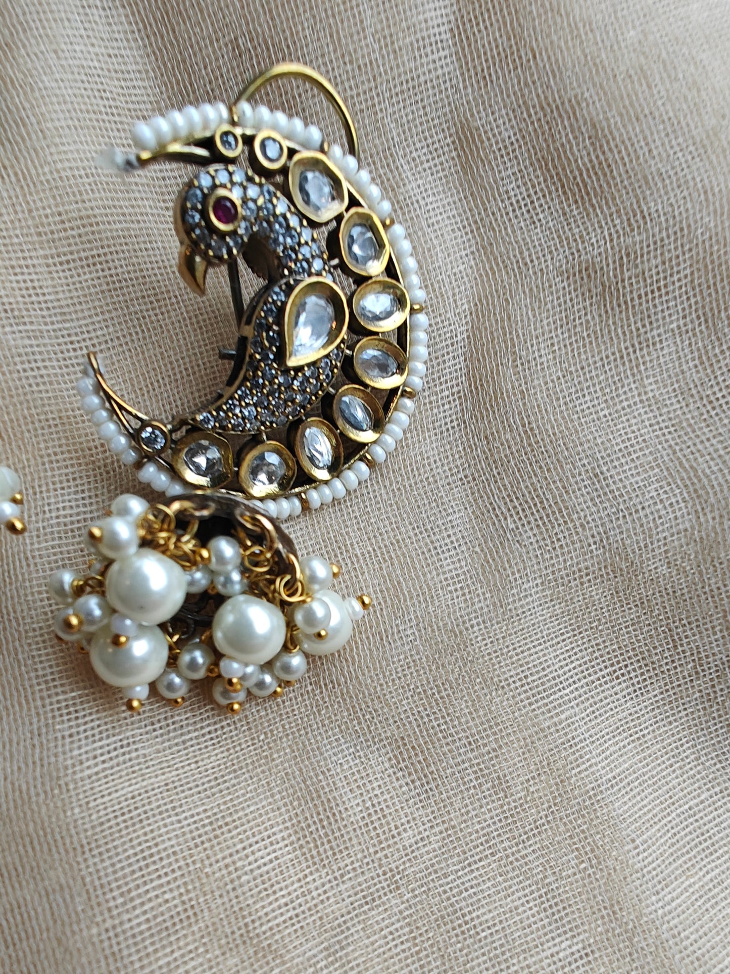 'Chaand-mor' jhumki earrings featuring a peacock nestled in a cresent