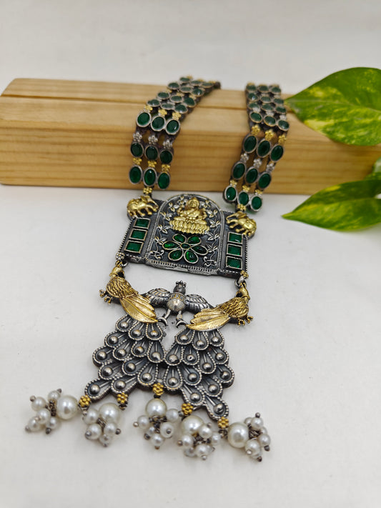 Dual tone chunky long necklace with emerald green stone inlay.The pendant depicts garud and has laksmi on it