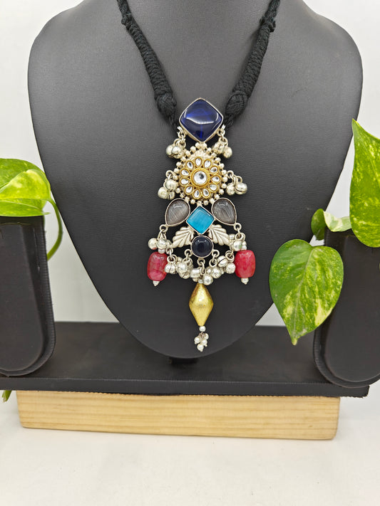 Tilism necklace with a pendant with different coloured stones ,kundan and ghungroos on a black string