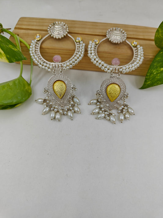 Earrings with a big ring design with pearls,and a dual tone hanging below