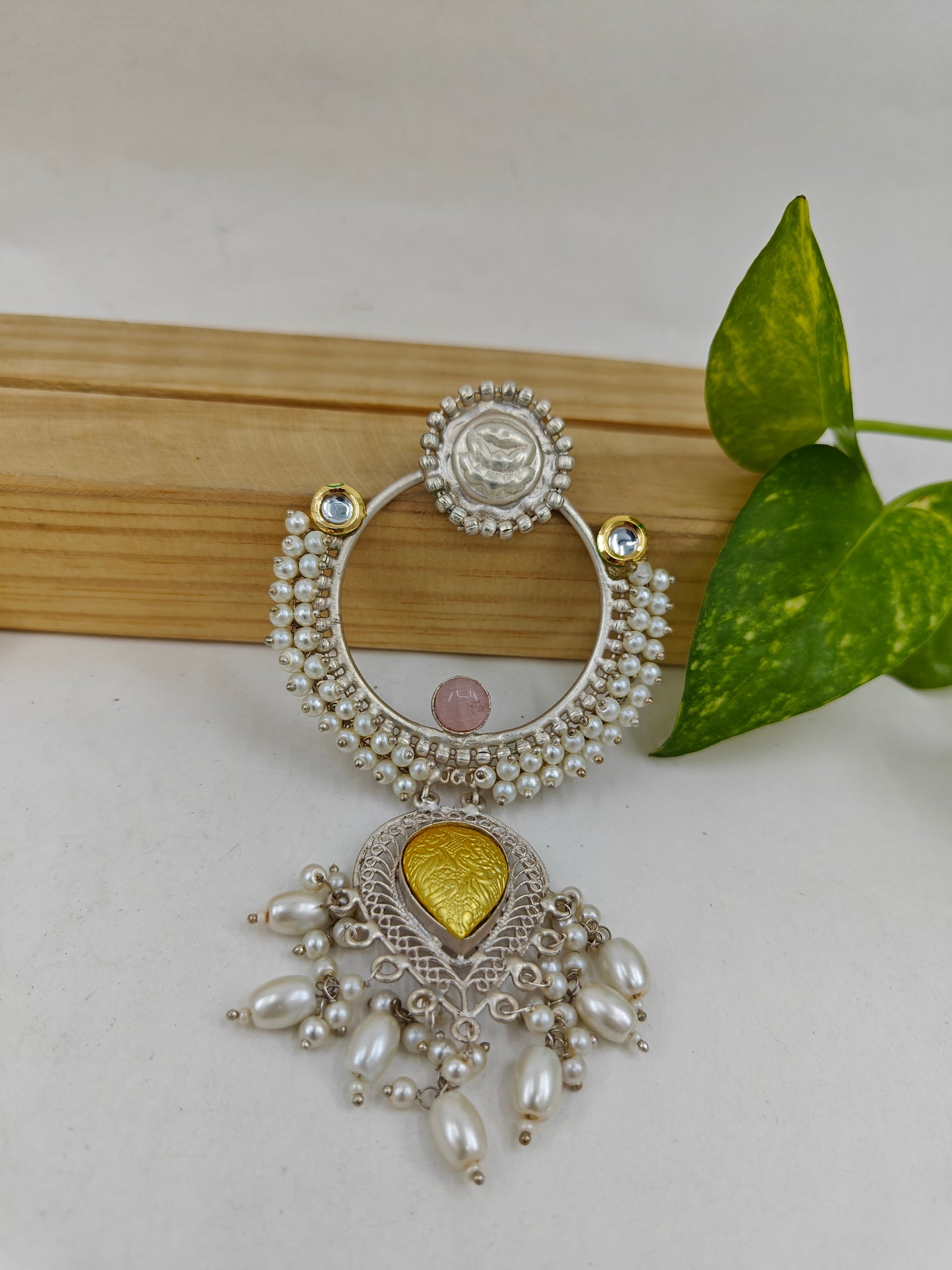 Earrings with a big ring design with pearls,and a dual tone hanging below