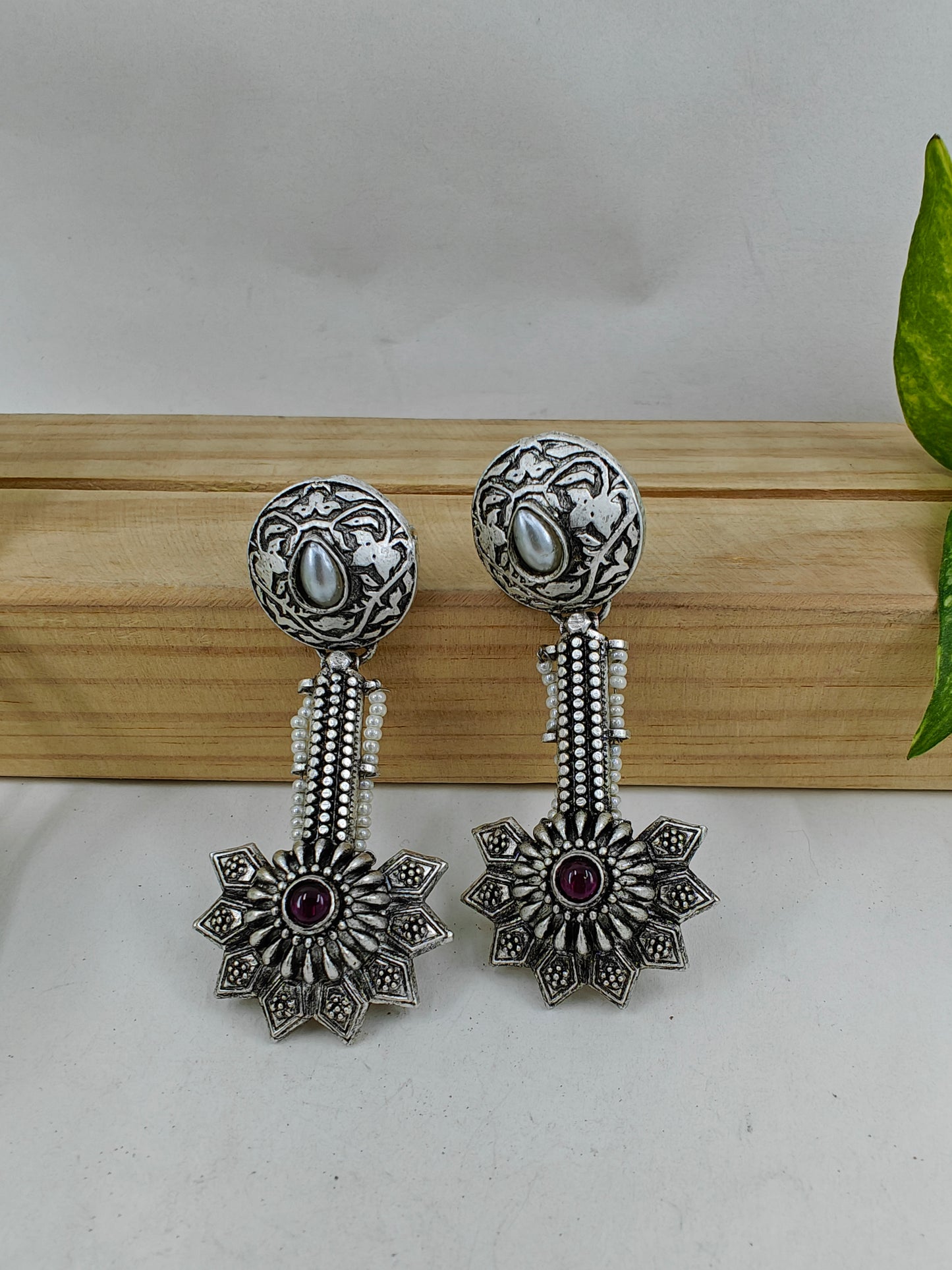 Earrings with carvings with a stud with pearl and hanging flower design