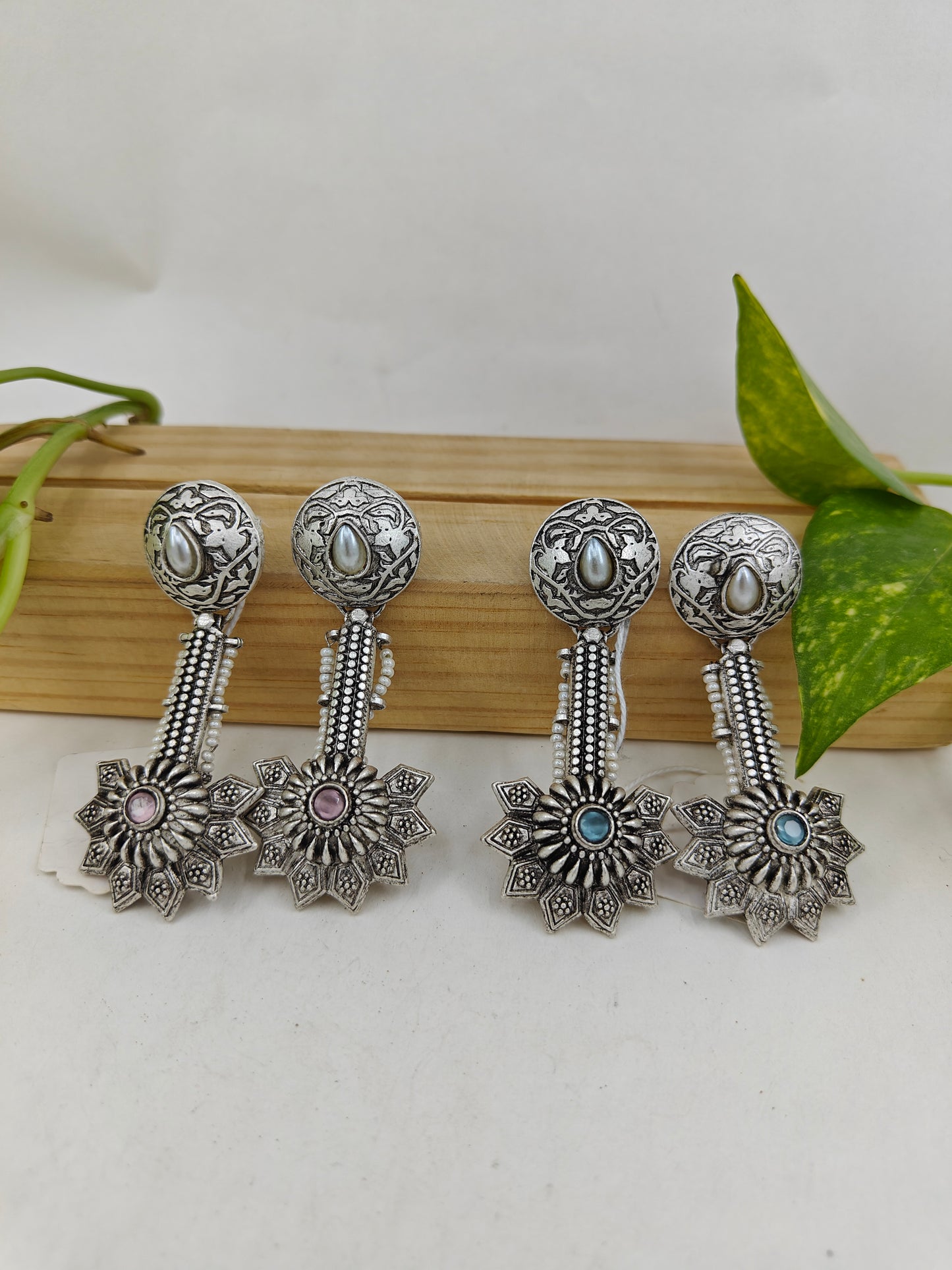 Earrings with carvings with a stud with pearl and hanging flower design