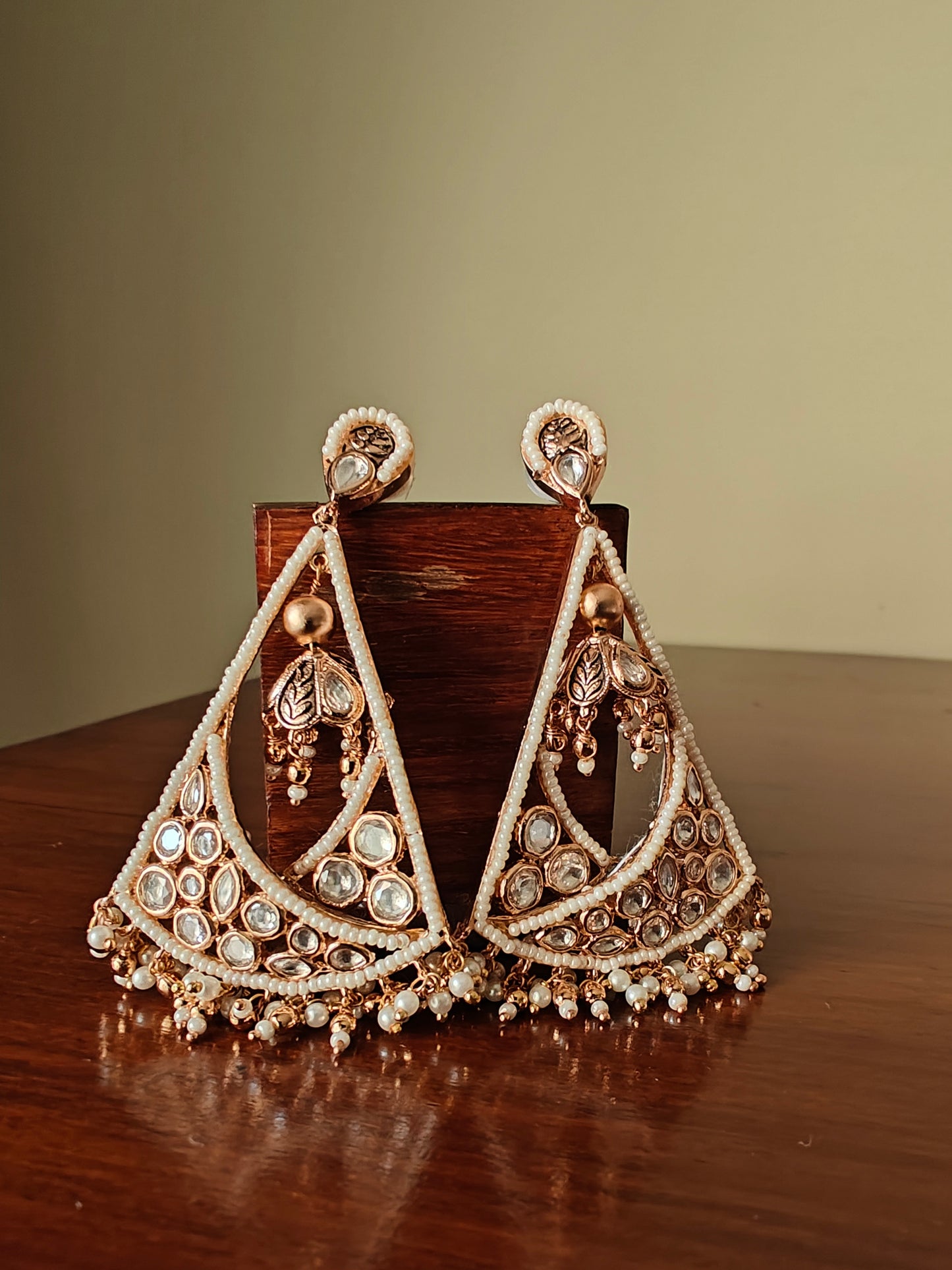 Poth pearl and Kundan triangular hanging earrings.