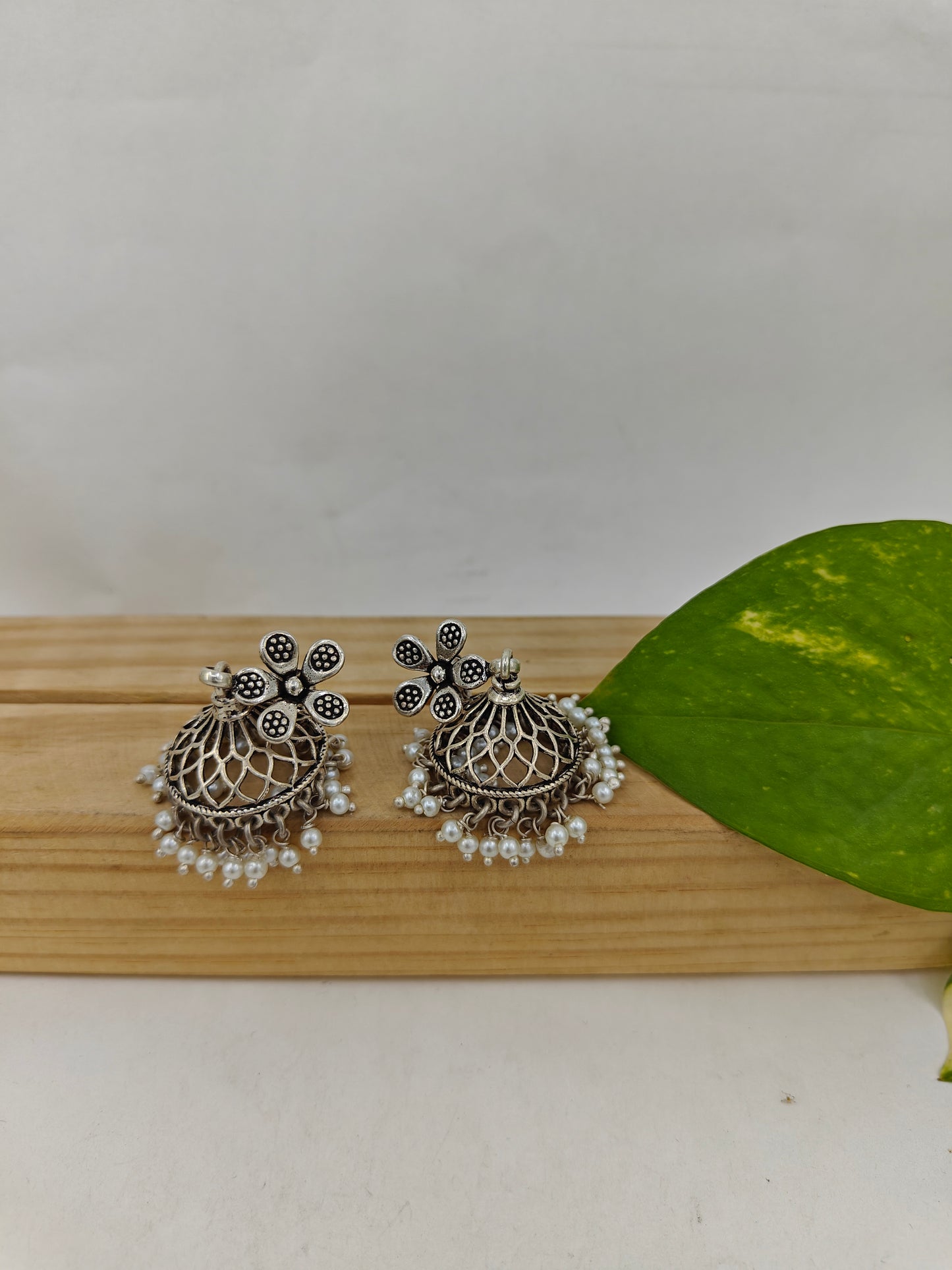 Silver jali jhumkis (earrings) on an open flower stud,pearl hangings