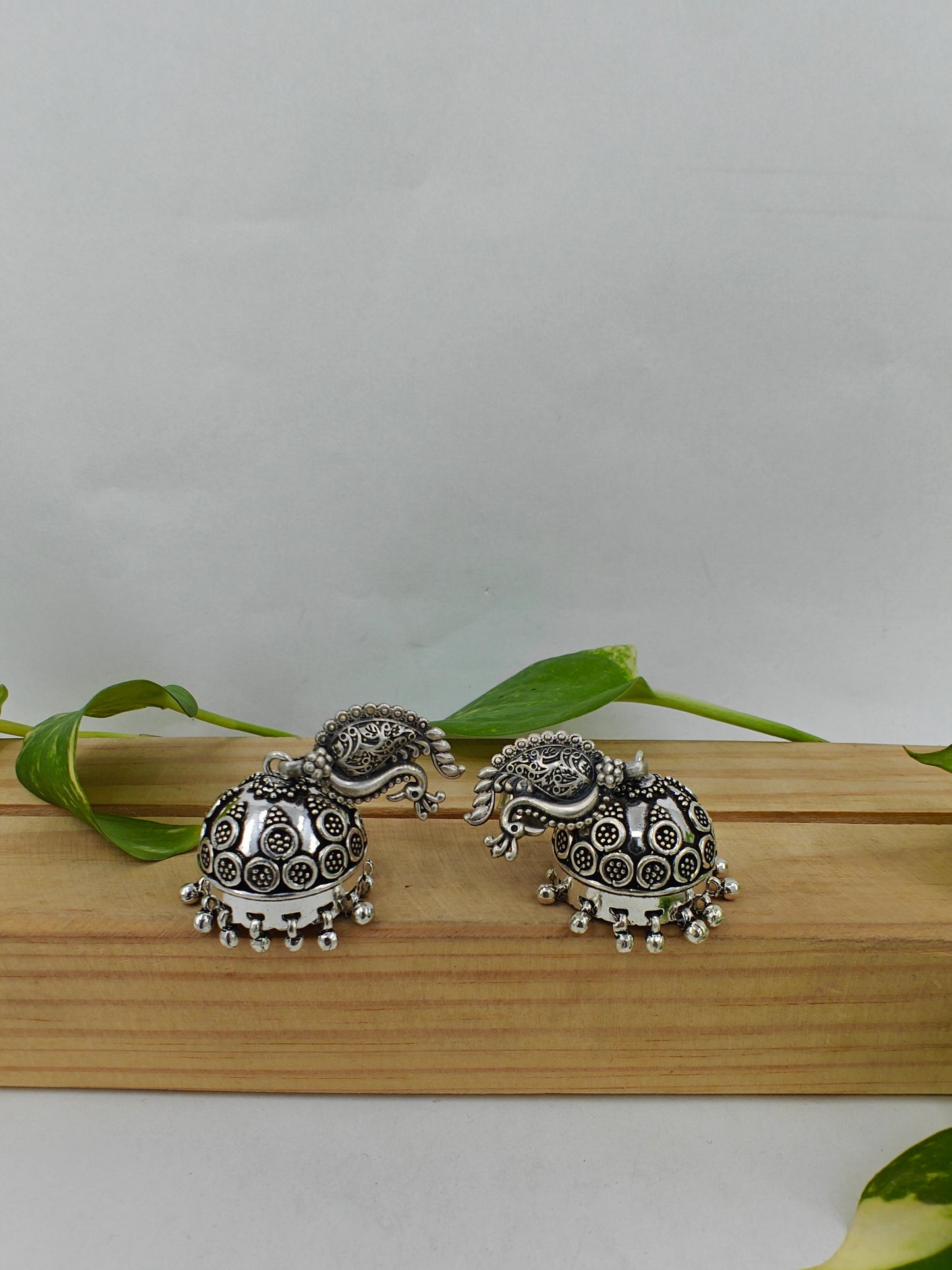 Silver jhumkas (earrings) on peacock stud, hanging ghungroos at the bottom