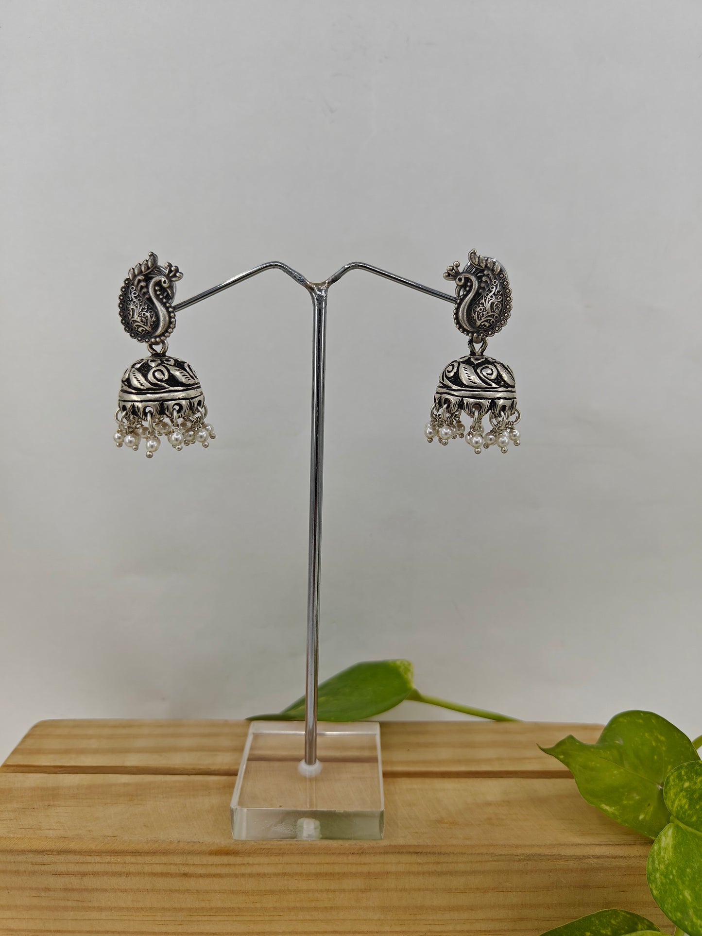 Silver jhumkis (earrings) with carvings on a peacock stud, pearl hangings