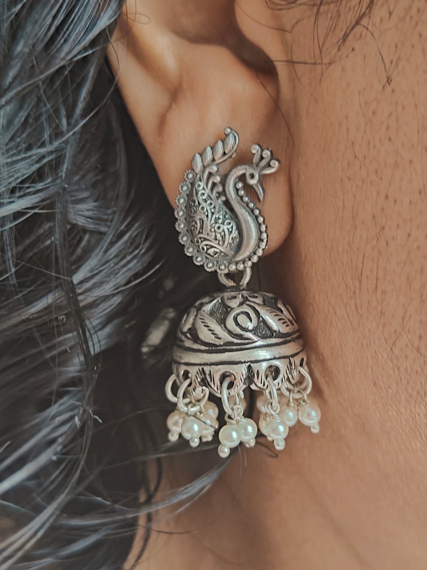 Silver jhumkis (earrings) with carvings on a peacock stud, pearl hangings