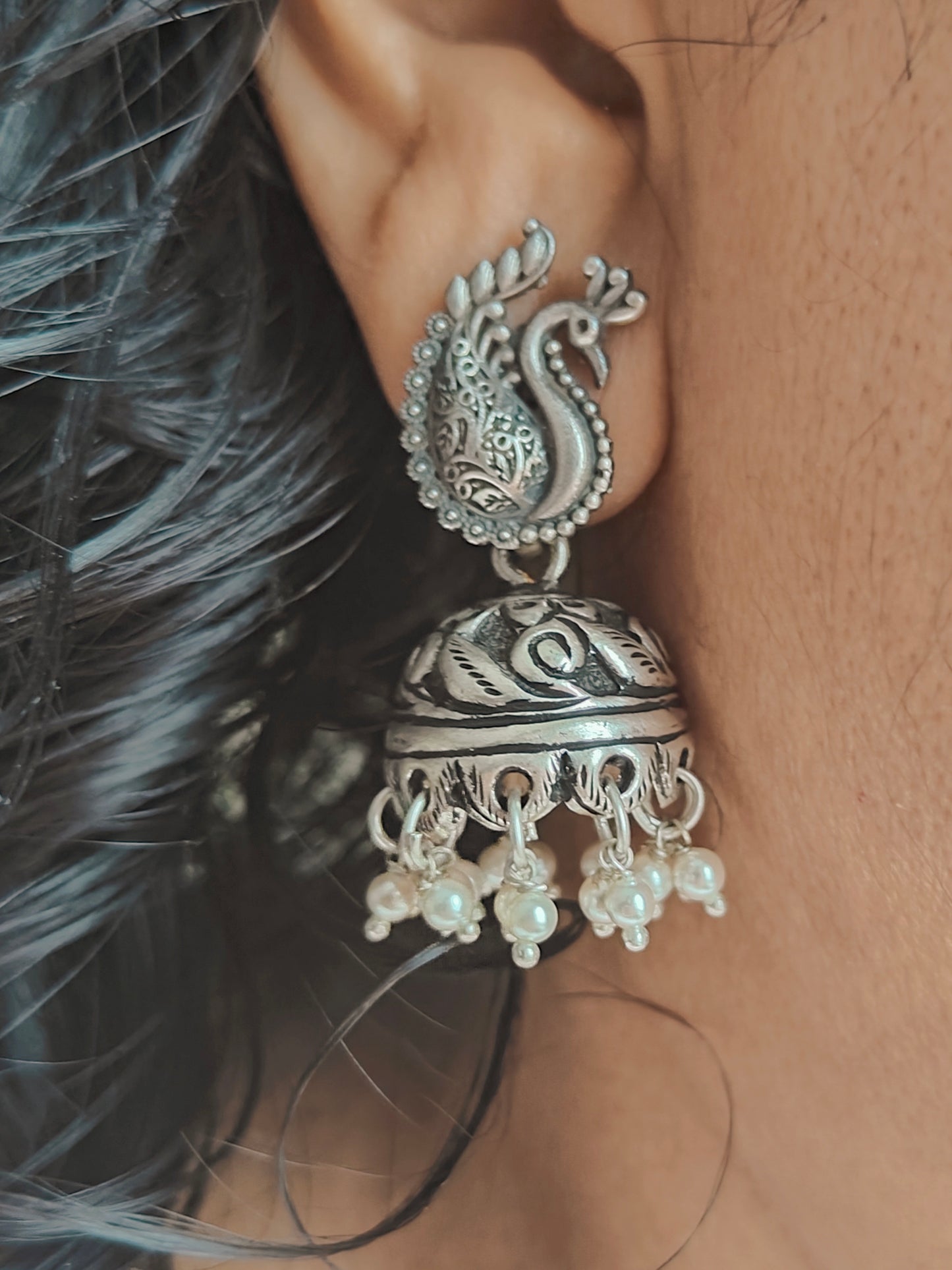 Silver jhumkis (earrings) with carvings on a peacock stud, pearl hangings